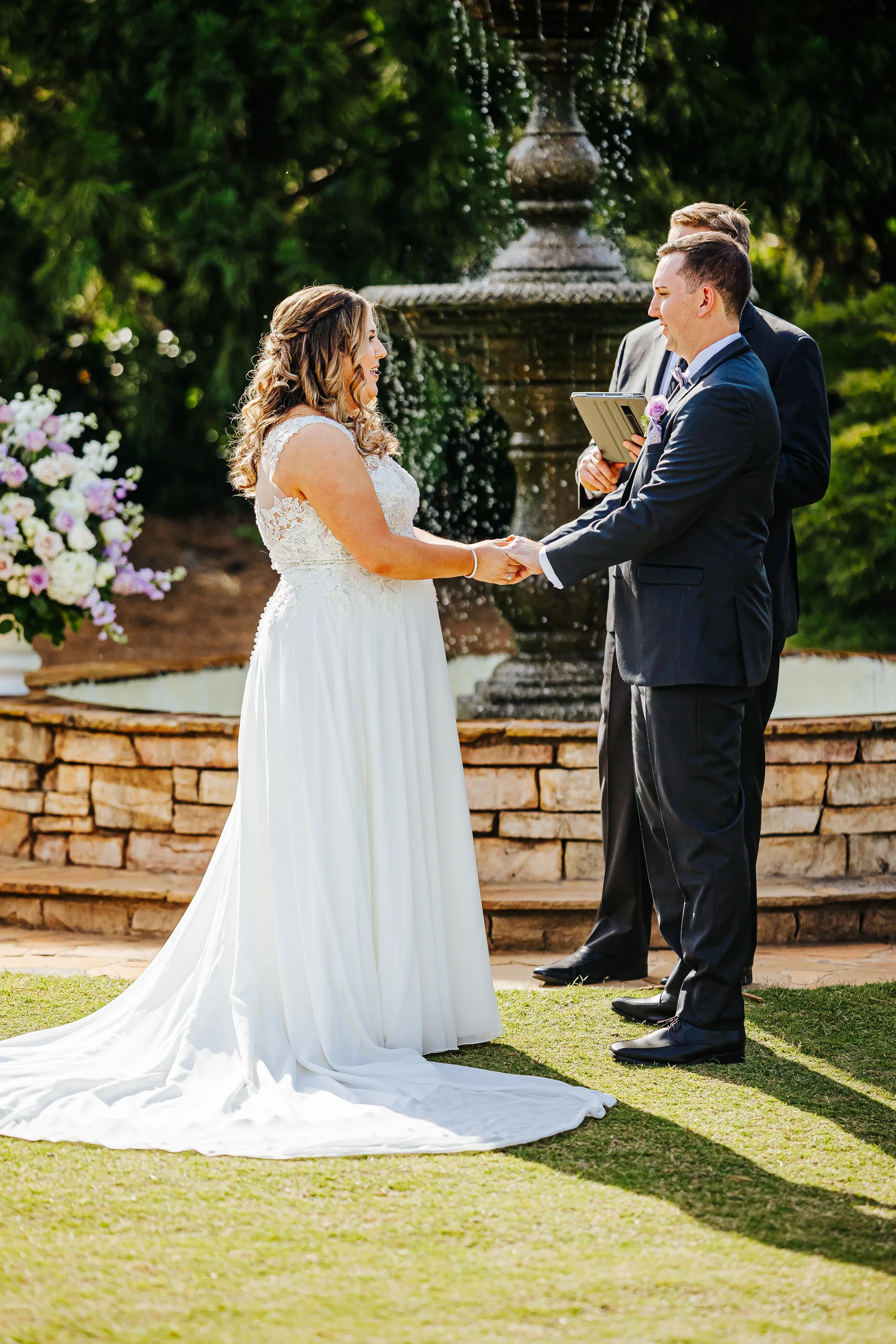 Wedding Ceremony: exchanging vows in front of the fountain at their wedding at the Country Club of Roswell in Roswell, GA