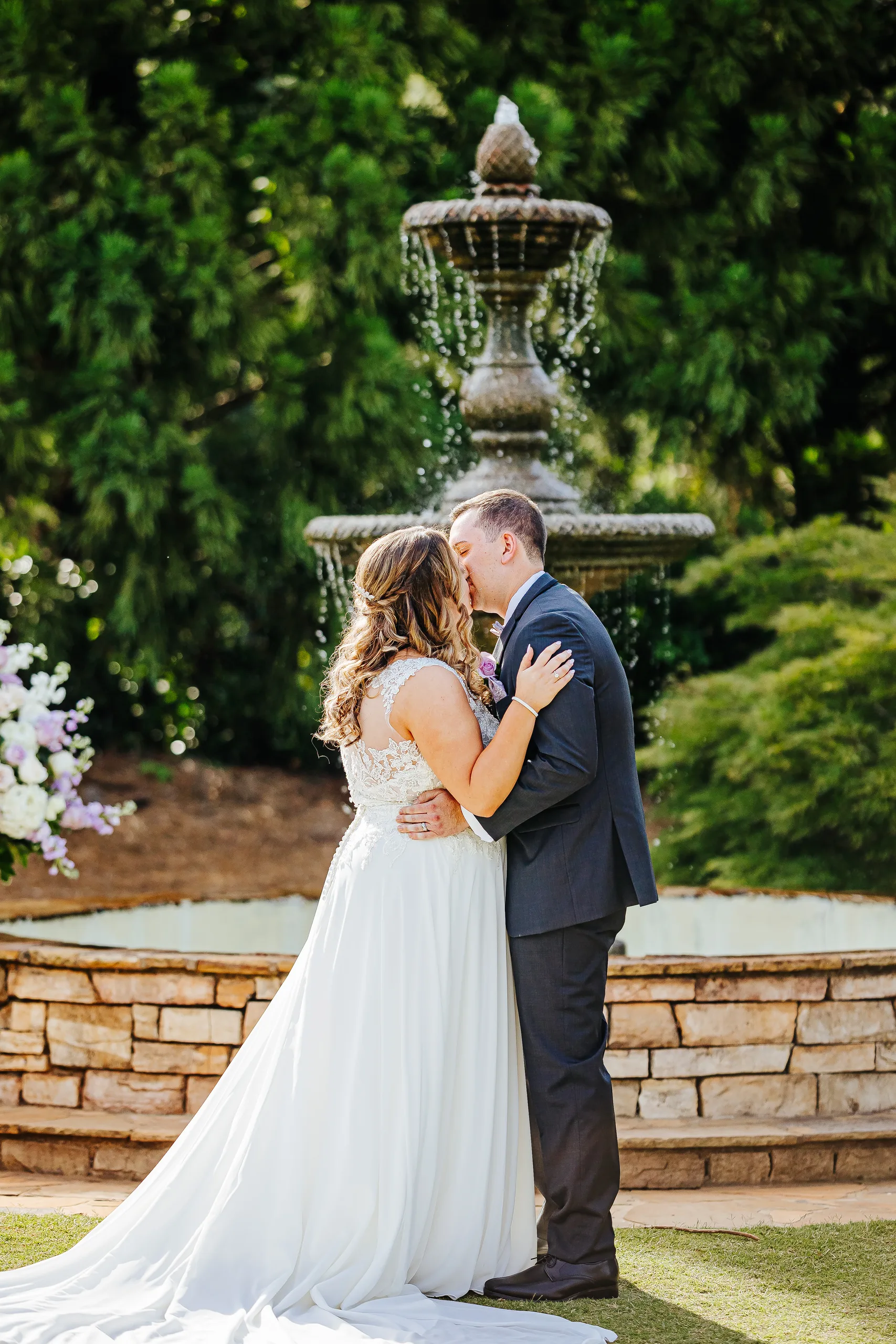 Wedding Ceremony: the first kiss in front of the fountain at their wedding at the Country Club of Roswell in Roswell, GA