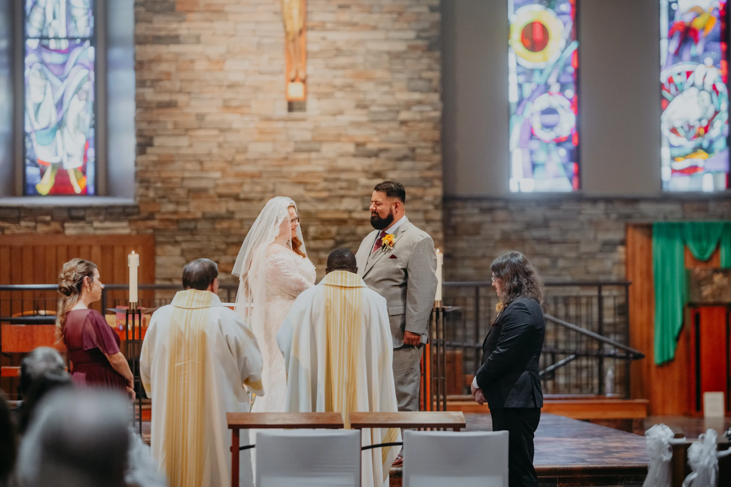 Wedding Ceremony: exchanging vows at the altar, at their wedding at St. Lawrence Catholic Church in Lawrenceville, GA