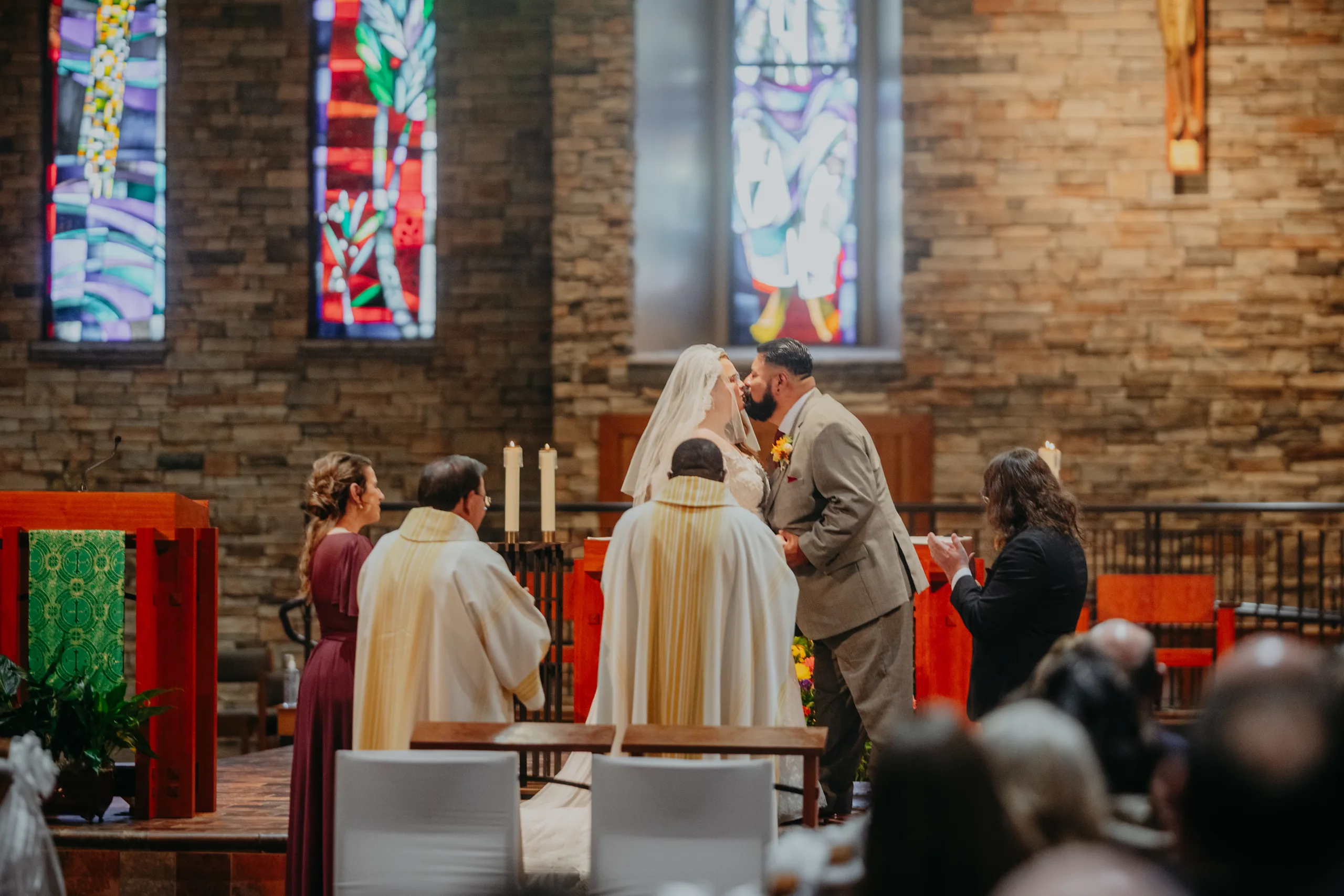 Wedding Ceremony: the first kiss at the altar, at their wedding at St. Lawrence Catholic Church in Lawrenceville, GA
