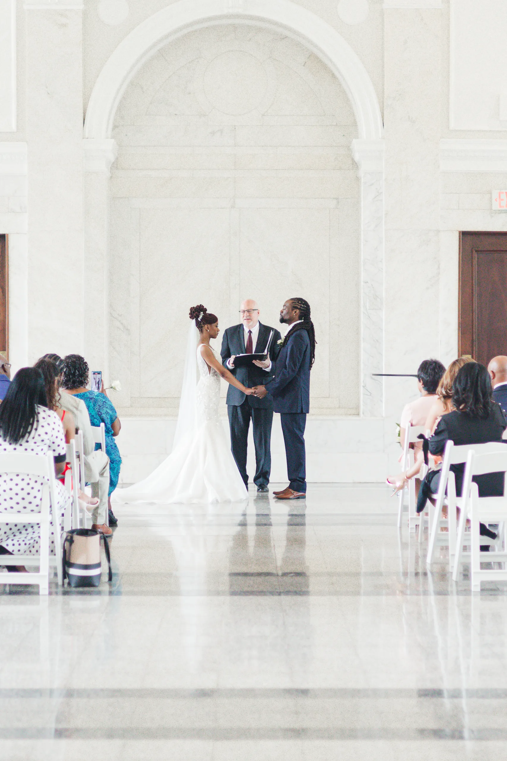 Wedding Ceremony: holding hands during the vows, at their wedding at the Historic DeKalb Courthouse in Decatur, GA