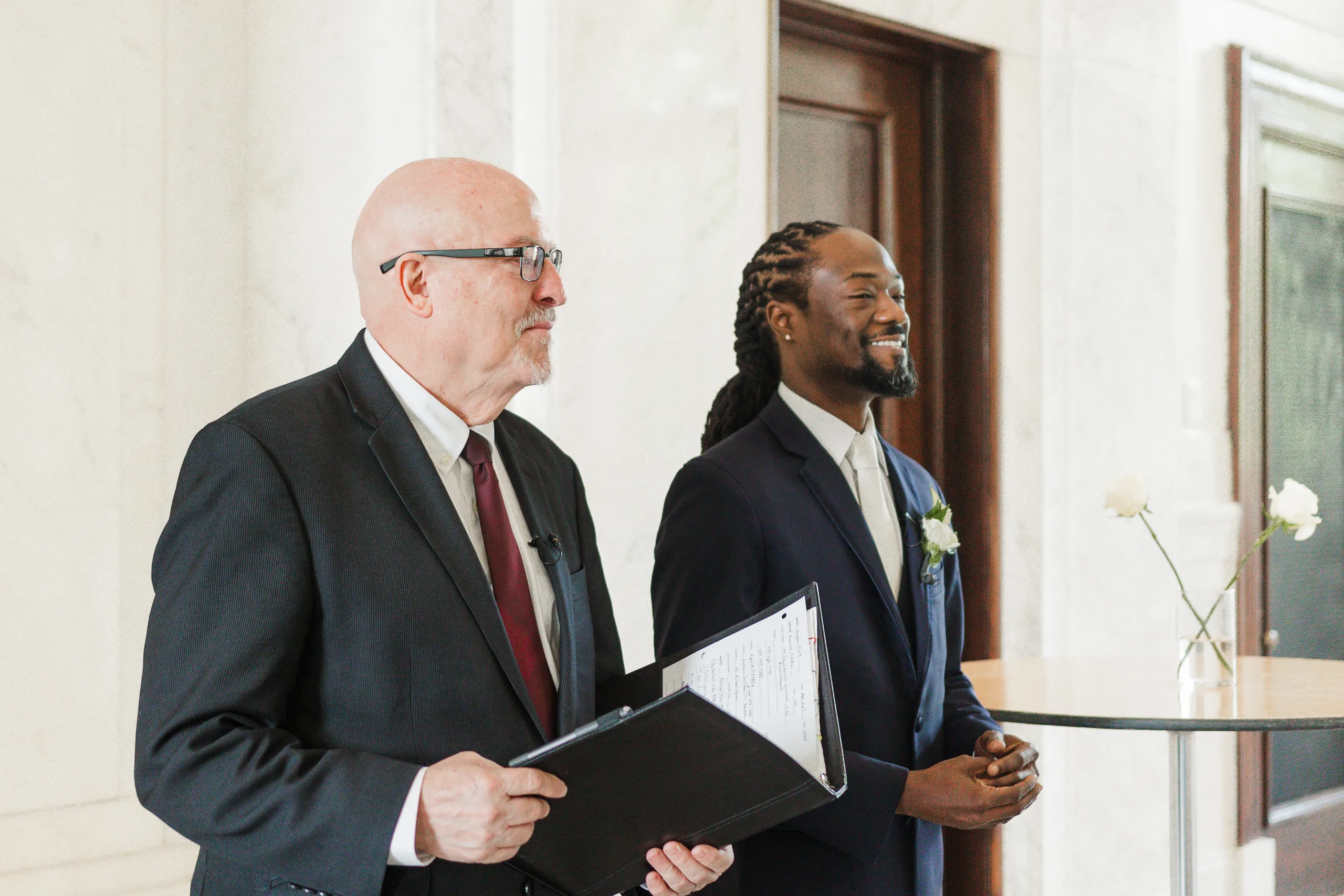 Wedding Ceremony: the groom and officiant waiting at the front, at their wedding at the Historic DeKalb Courthouse in Decatur, GA