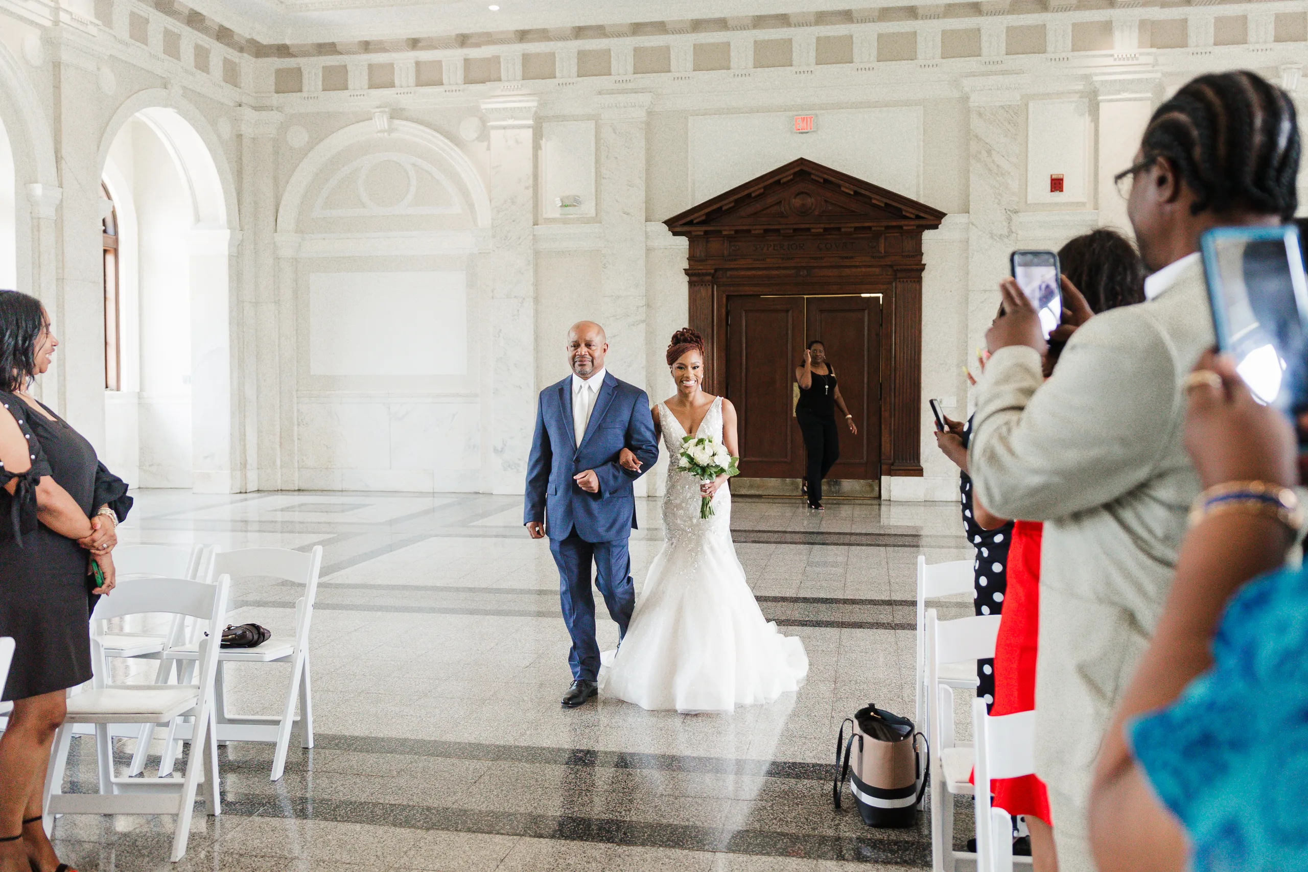 Wedding Ceremony: guests turning to watch the bride come in, at their wedding at the Historic DeKalb Courthouse in Decatur, GA