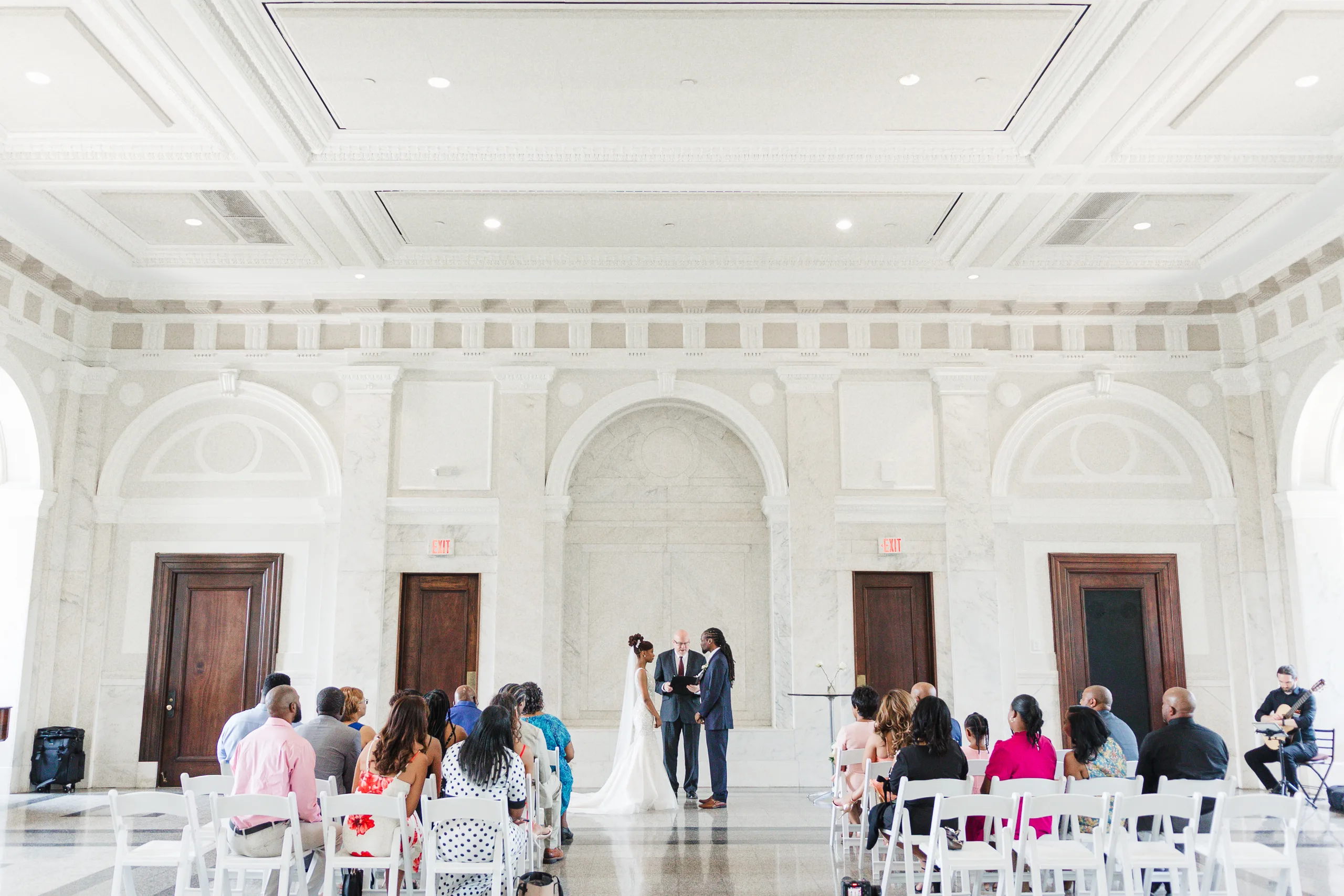 Wedding Ceremony: the ceremony in the courtroom with its marble walls and arched doorways, at their wedding at the Historic DeKalb Courthouse in Decatur, GA