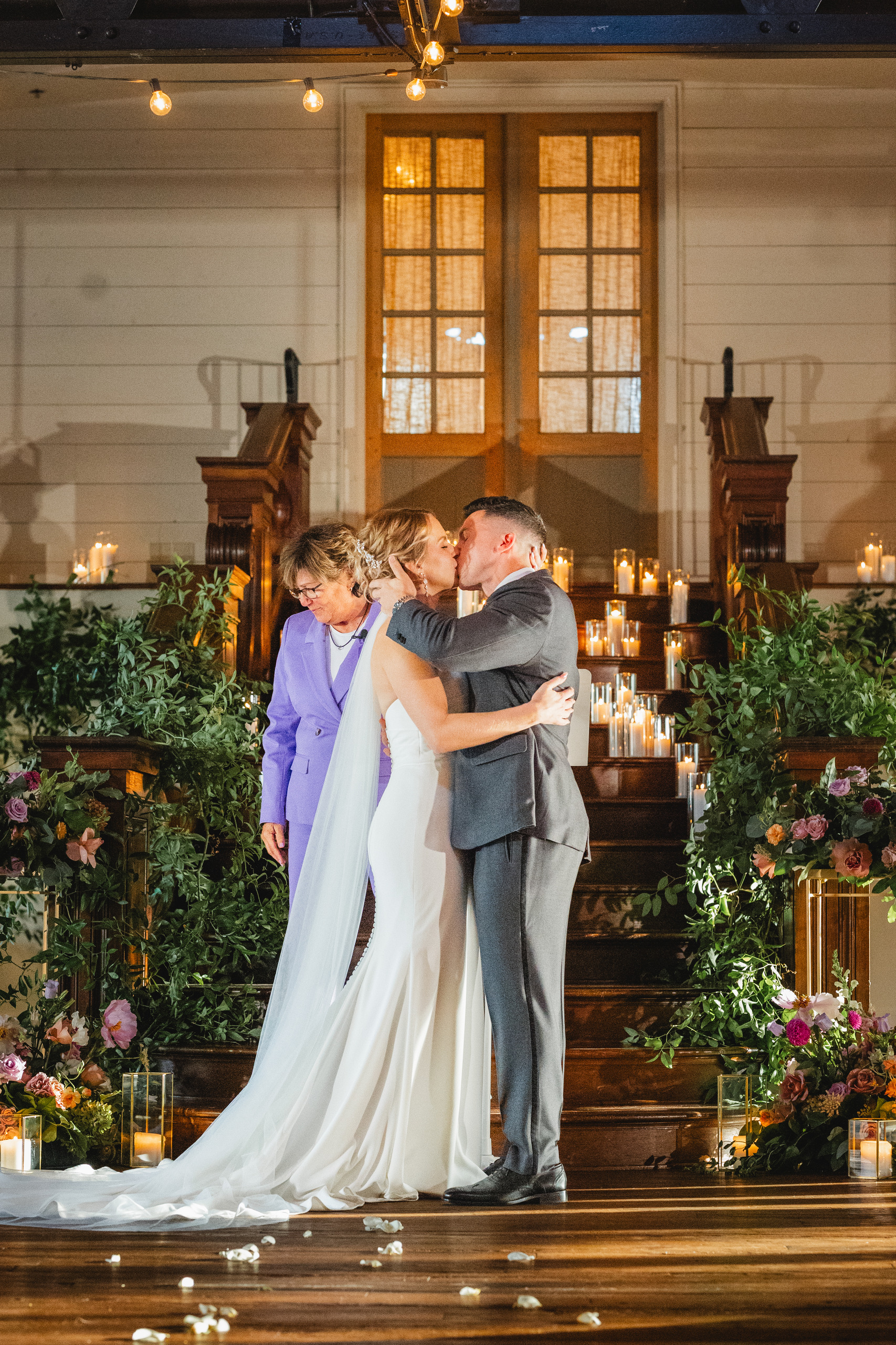 Wedding Ceremony: the first kiss on the candlelit staircase, at their wedding at Summerour Studio in Atlanta, GA
