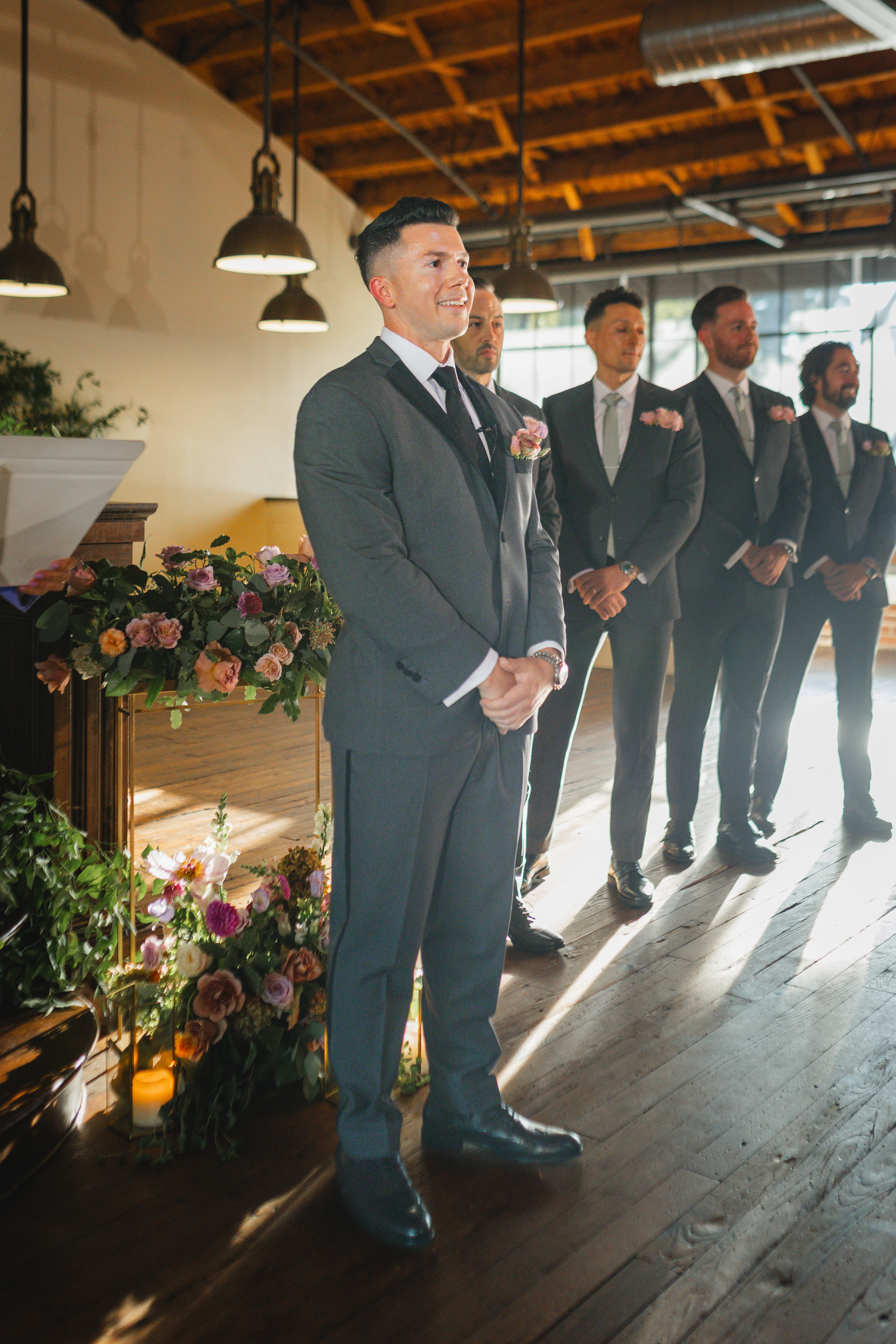 Wedding Ceremony: the groom and his groomsmen watching her come in, at their wedding at Summerour Studio in Atlanta, GA