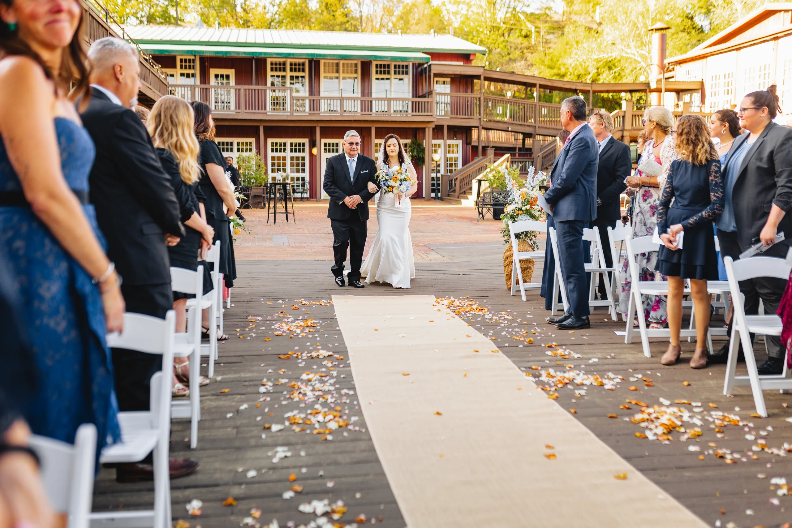 Wedding Ceremony: her dad walking her down the aisle on the deck at their wedding at Ivy Hall at Roswell Mill in Roswell, GA