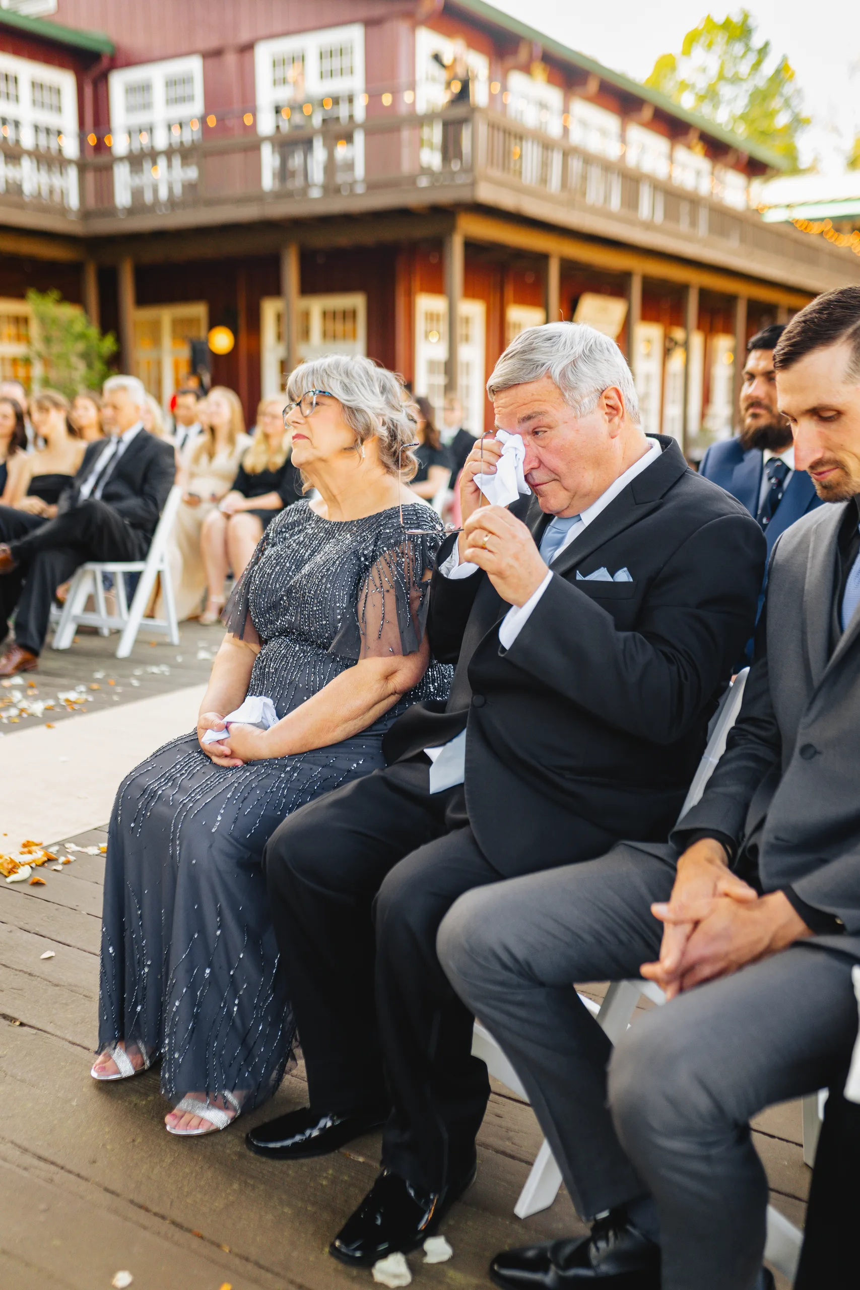 Wedding Ceremony: family in the front row wiping away tears at their wedding at Ivy Hall at Roswell Mill in Roswell, GA