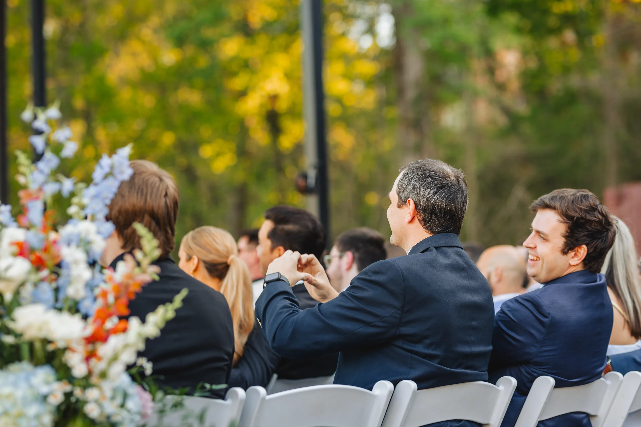 Wedding Ceremony: guests smiling during the ceremony at their wedding at Ivy Hall at Roswell Mill in Roswell, GA