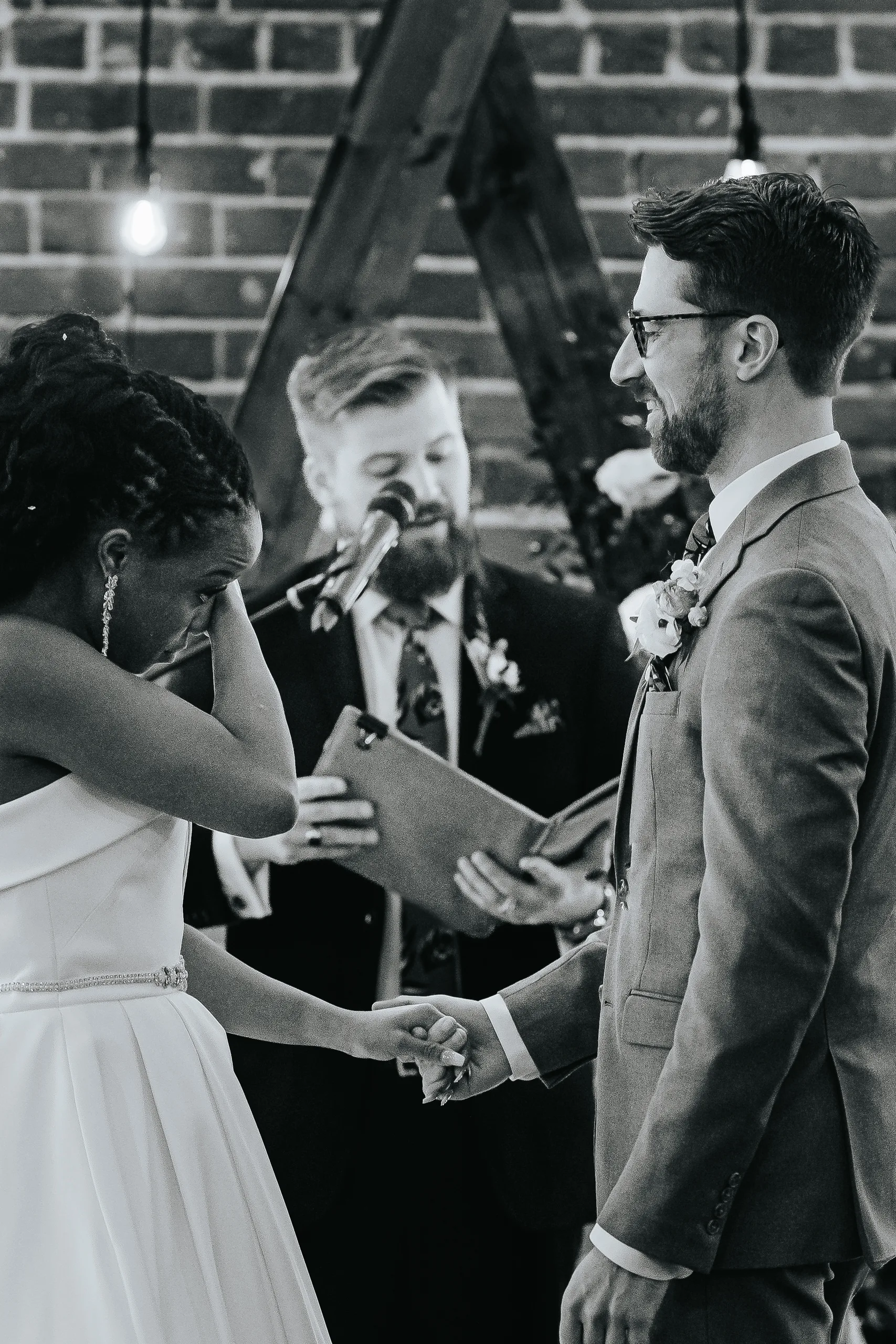 Wedding Ceremony: the bride wiping away a tear during the vows, in black and white, at their wedding at Terminus 330 in Atlanta, GA