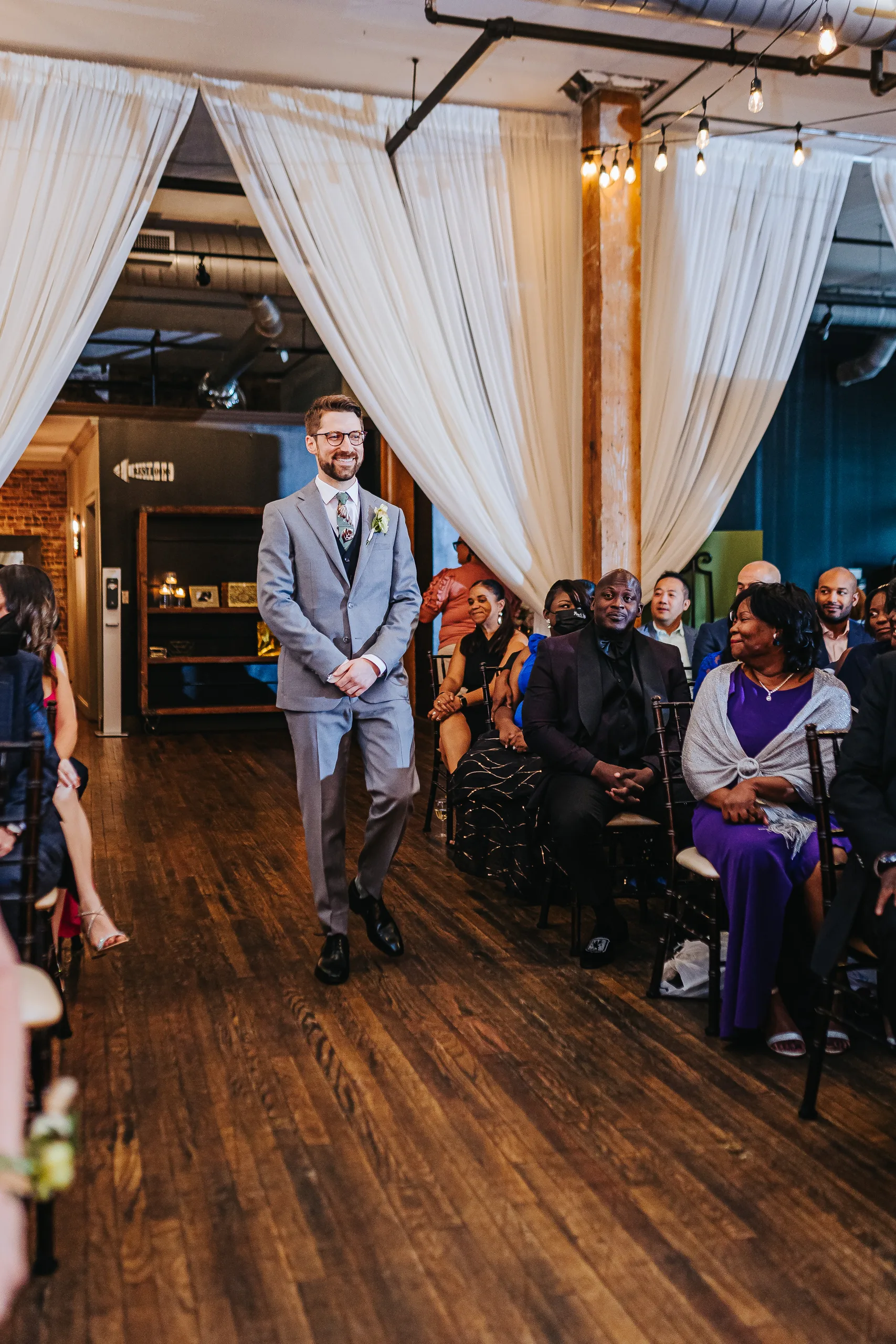 Wedding Ceremony: the groom walking down the aisle, at their wedding at Terminus 330 in Atlanta, GA