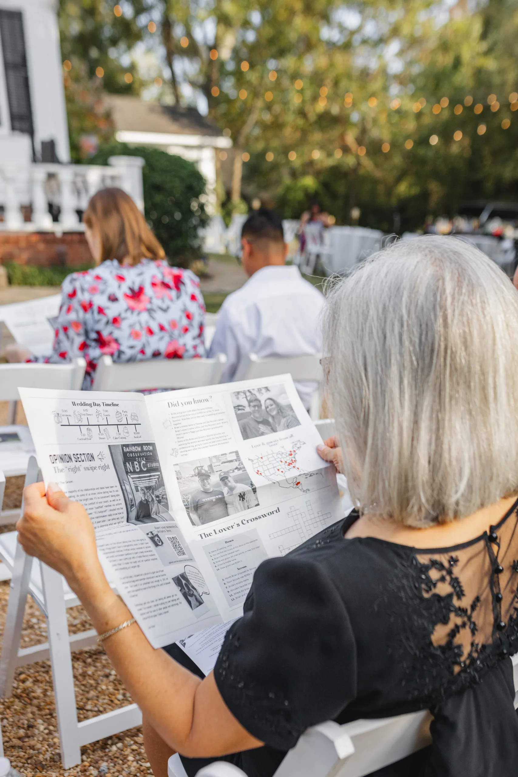 Wedding Ceremony: a guest reading the newspaper program, at their wedding at Naylor Hall in Roswell, GA