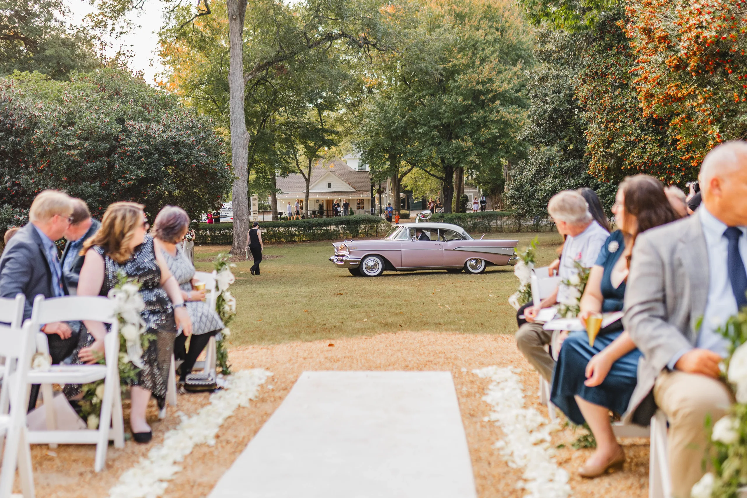 Wedding Ceremony: the pink Chevrolet pulling up behind the guests, at their wedding at Naylor Hall in Roswell, GA