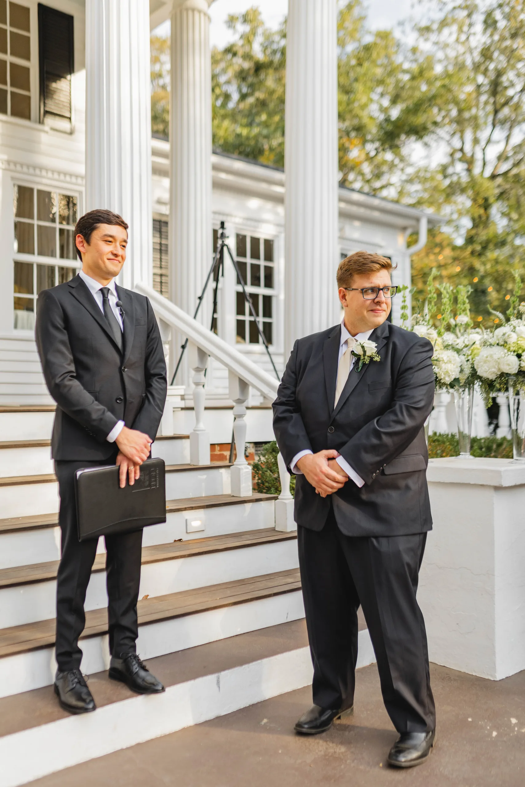 Wedding Ceremony: the groom and officiant waiting at the front steps, at their wedding at Naylor Hall in Roswell, GA