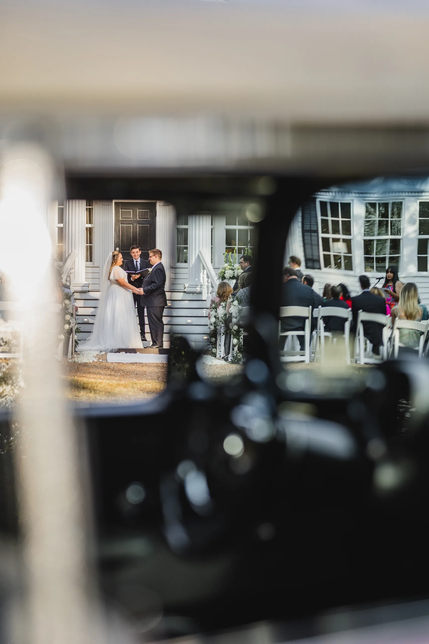 Wedding Ceremony: the vows seen through the window of the pink Chevrolet, at their wedding at Naylor Hall in Roswell, GA