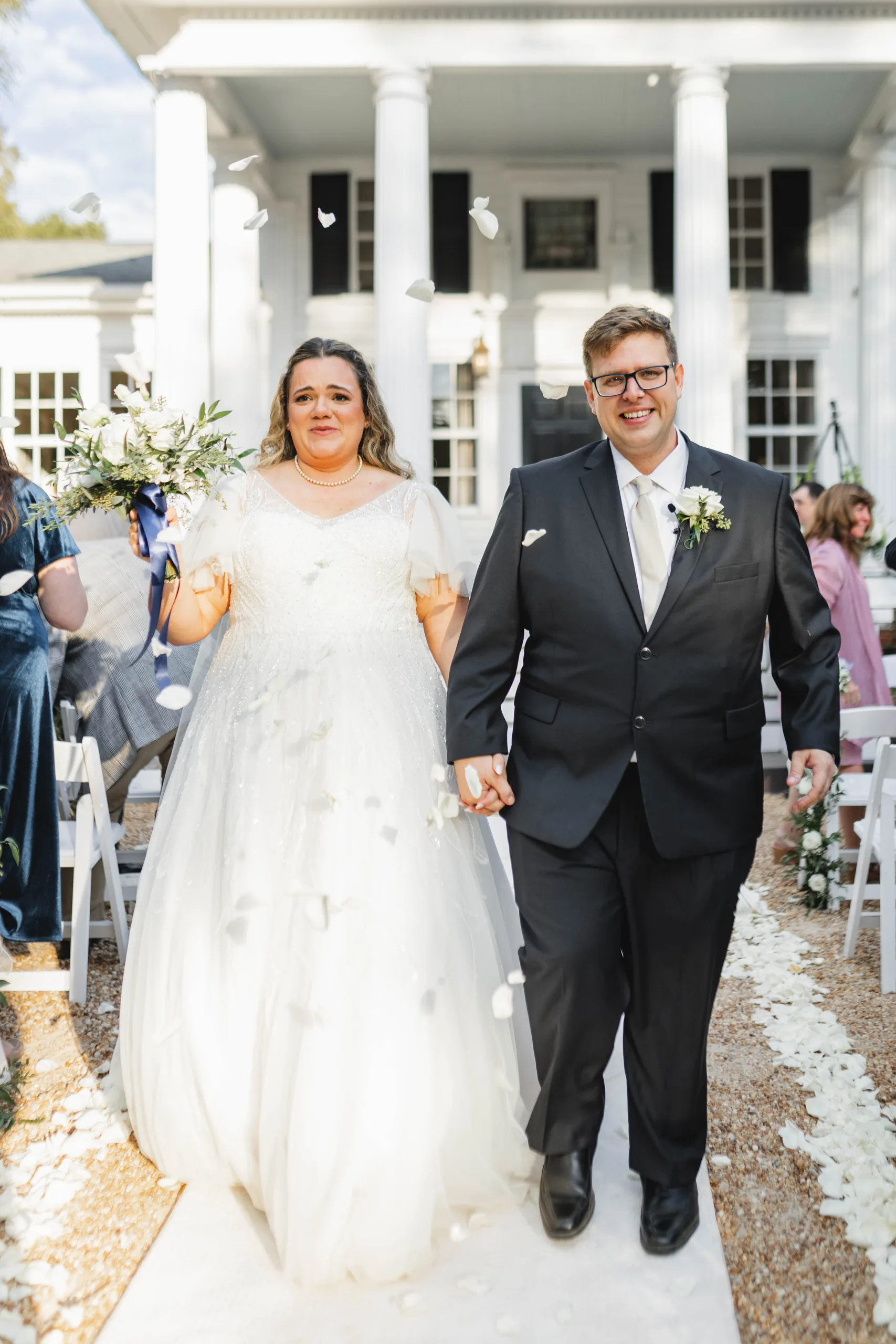 Wedding Ceremony: walking back up the aisle through falling petals, at their wedding at Naylor Hall in Roswell, GA