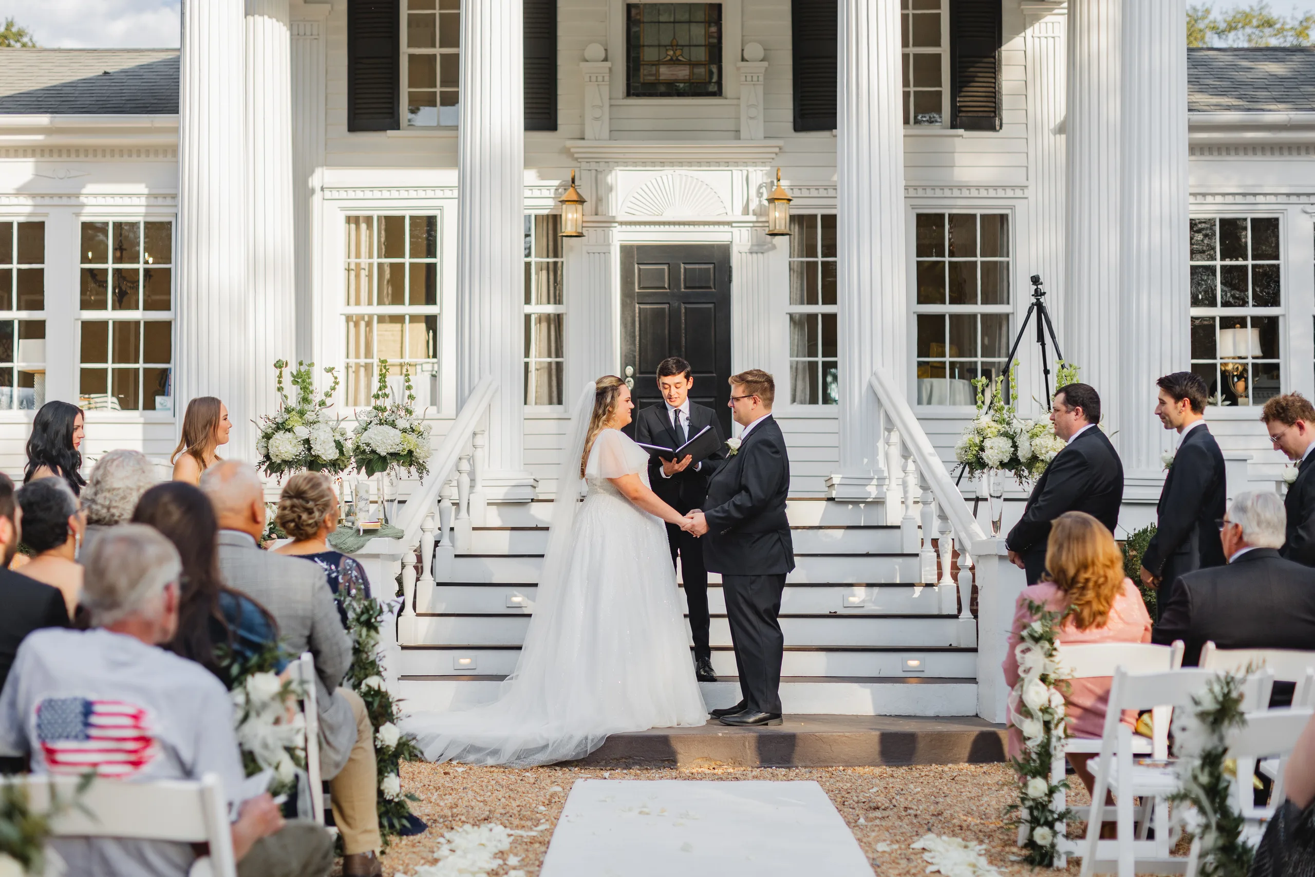 Wedding Ceremony: exchanging vows at the foot of the front steps, at their wedding at Naylor Hall in Roswell, GA