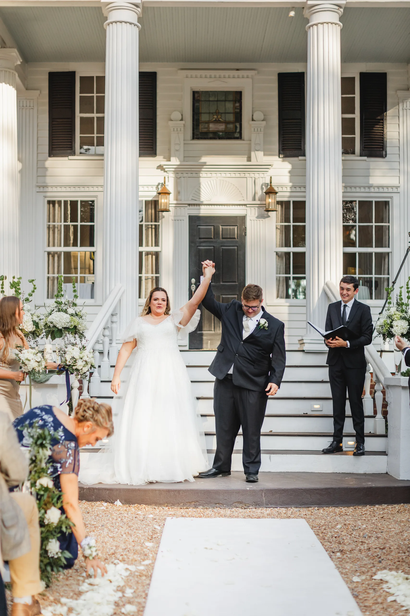 Wedding Ceremony: their hands thrown up in the air after the kiss, at their wedding at Naylor Hall in Roswell, GA