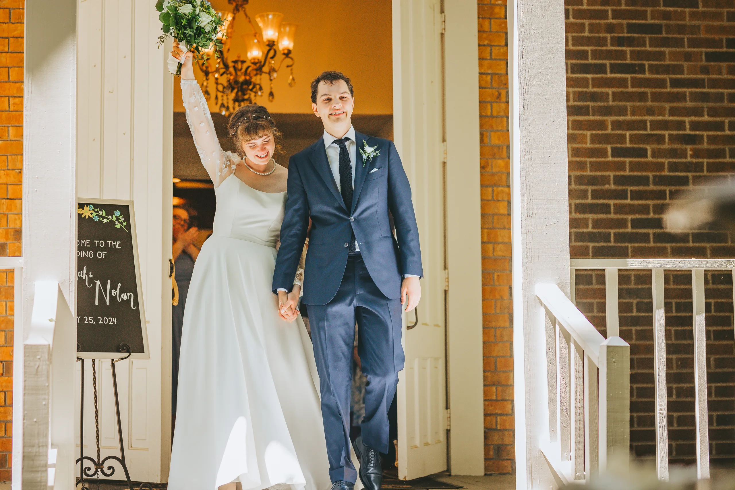 Wedding Ceremony: walking out the chapel doors with her bouquet in the air, at their wedding at the Chapel at Simpsonwood Park in Peachtree Corners, GA
