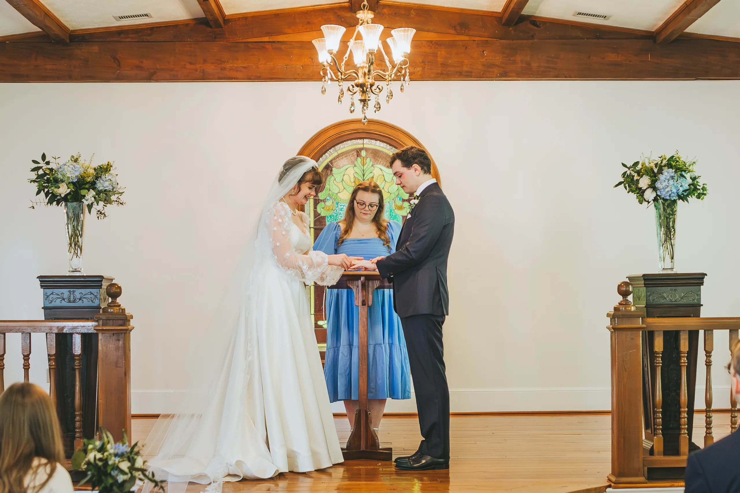 Wedding Ceremony: holding hands during the vows, at their wedding at the Chapel at Simpsonwood Park in Peachtree Corners, GA