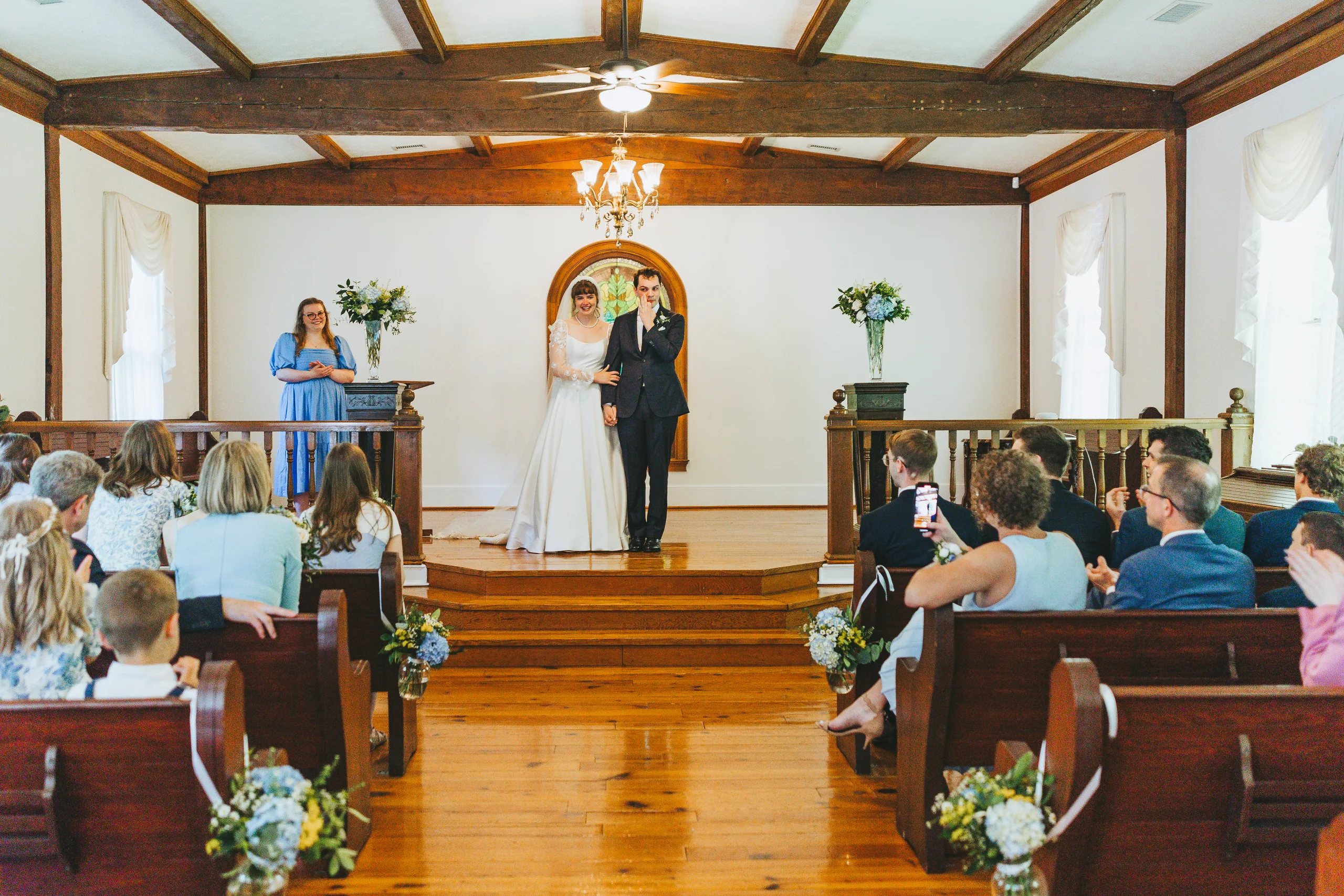Wedding Ceremony: the ceremony seen from the pews, at their wedding at the Chapel at Simpsonwood Park in Peachtree Corners, GA