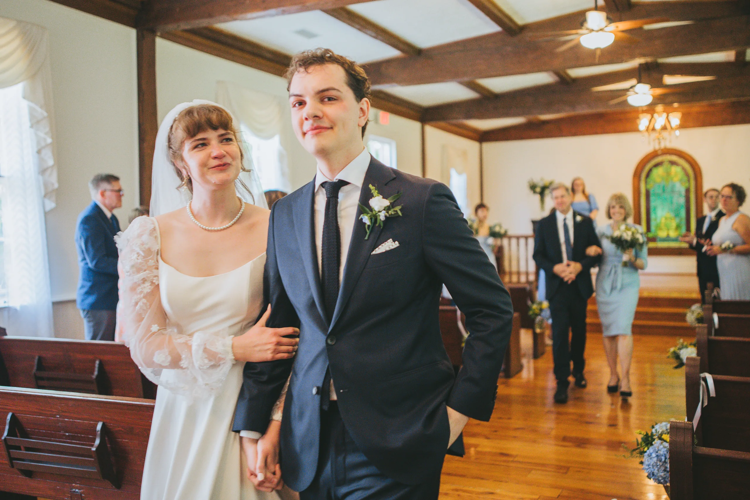 Wedding Ceremony: heading out with family behind them, at their wedding at the Chapel at Simpsonwood Park in Peachtree Corners, GA