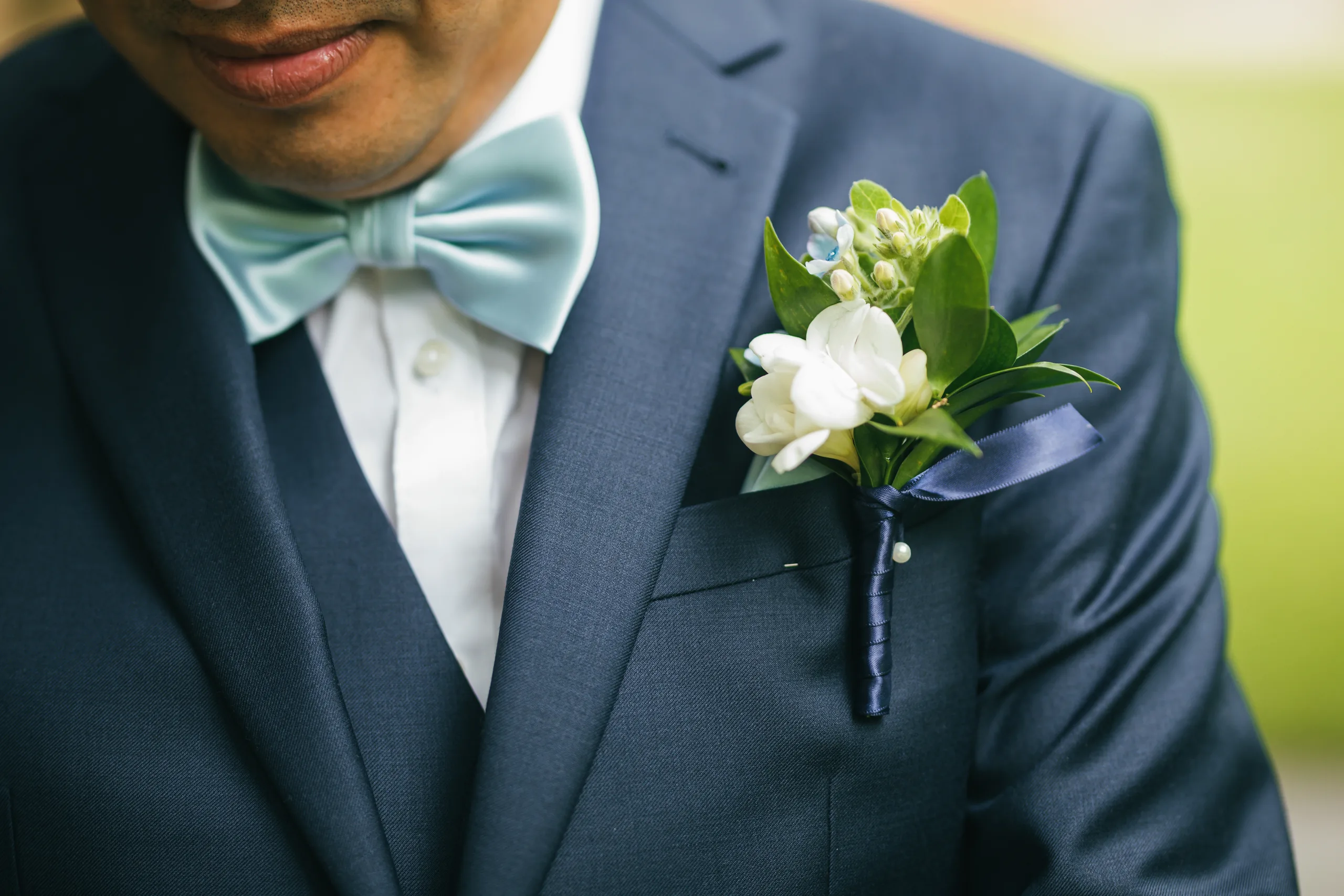 Wedding Details: his white boutonniere and light blue bow tie at a wedding at Holy Cross Catholic Church in Atlanta, GA