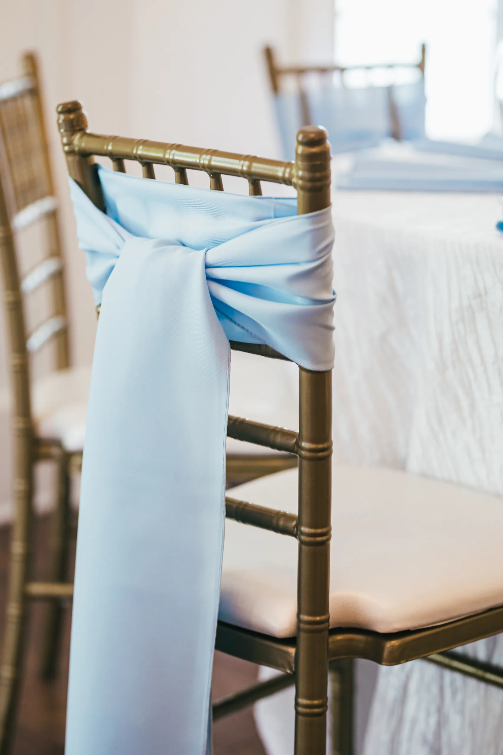 Reception Details: a light blue sash on a gold chair at a wedding at the Payne-Corley House in Duluth, GA