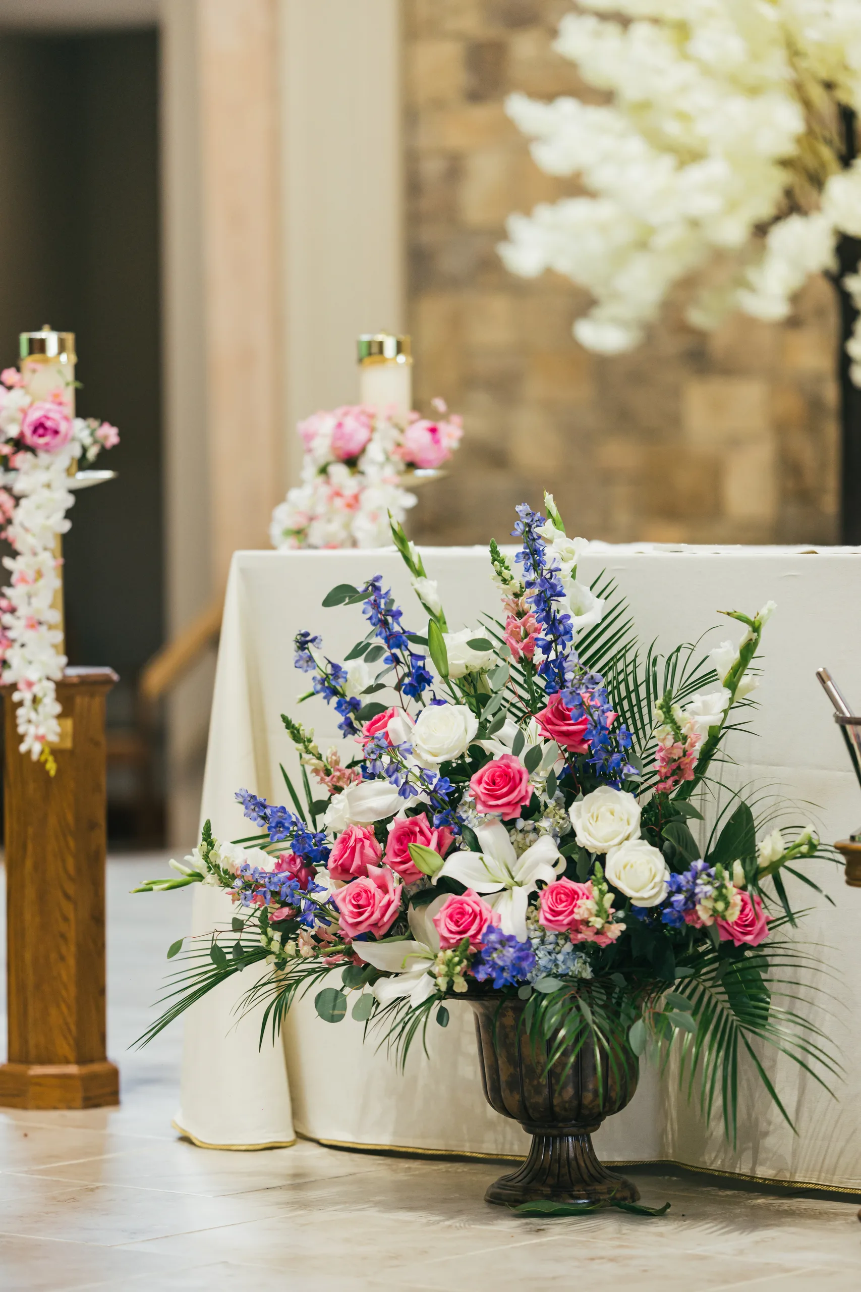Ceremony Details: pink, white and blue flowers beside the altar at a wedding at Holy Cross Catholic Church in Atlanta, GA
