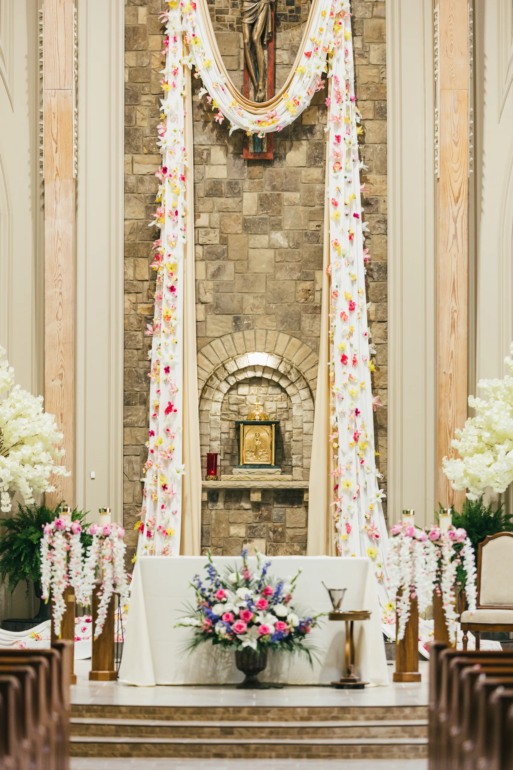 Ceremony Details: the altar decorated with flowers and garlands at a wedding at Holy Cross Catholic Church in Atlanta, GA