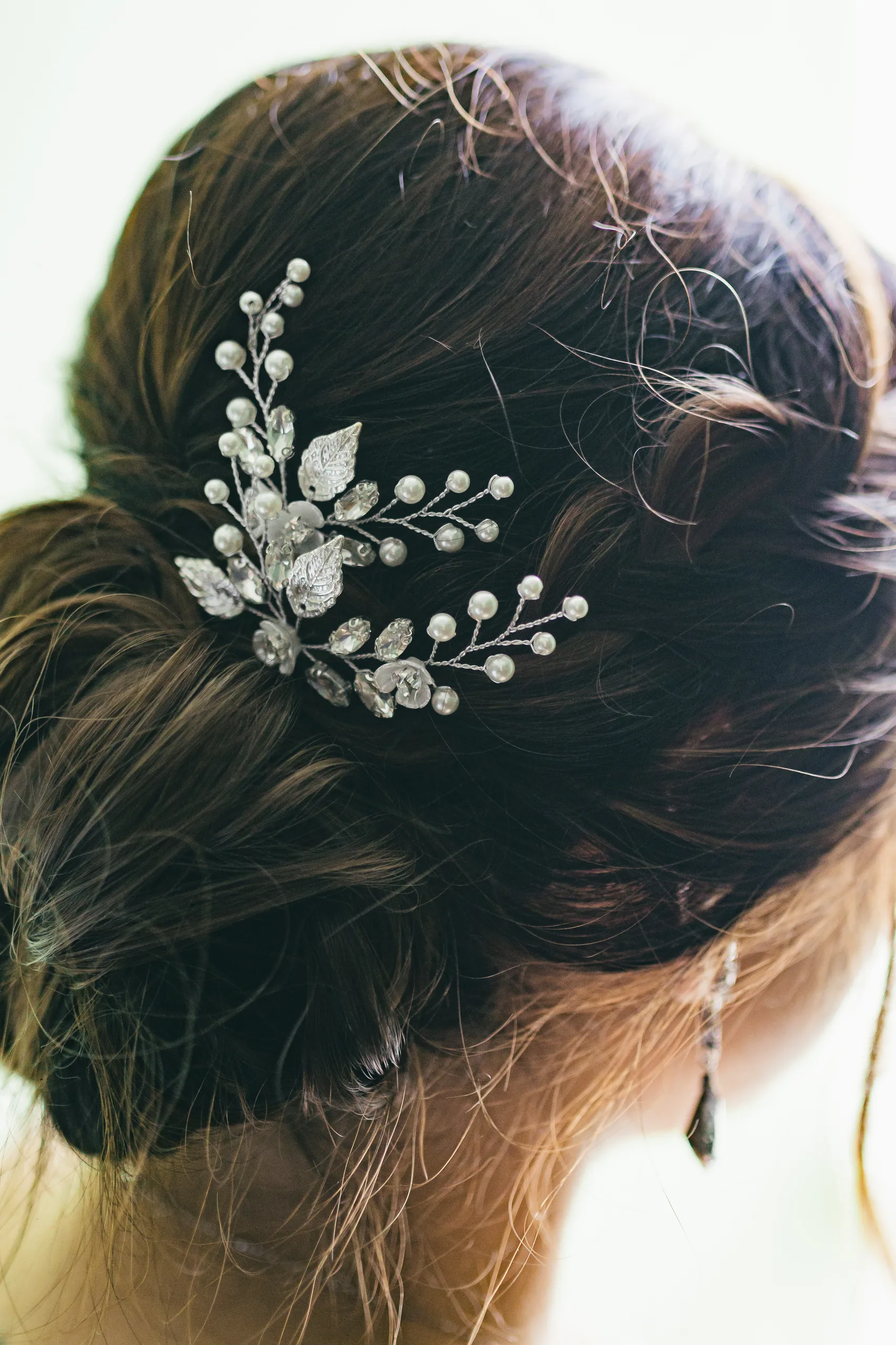 Getting Ready: her crystal hair comb in her low bun before their wedding at Holy Cross Catholic Church in Atlanta, GA