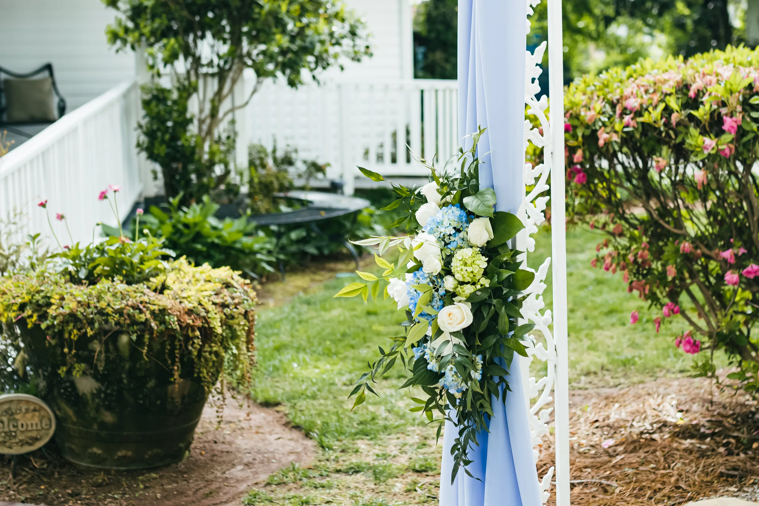 Wedding Details: flowers on the draped arch in the garden at a wedding at the Payne-Corley House in Duluth, GA
