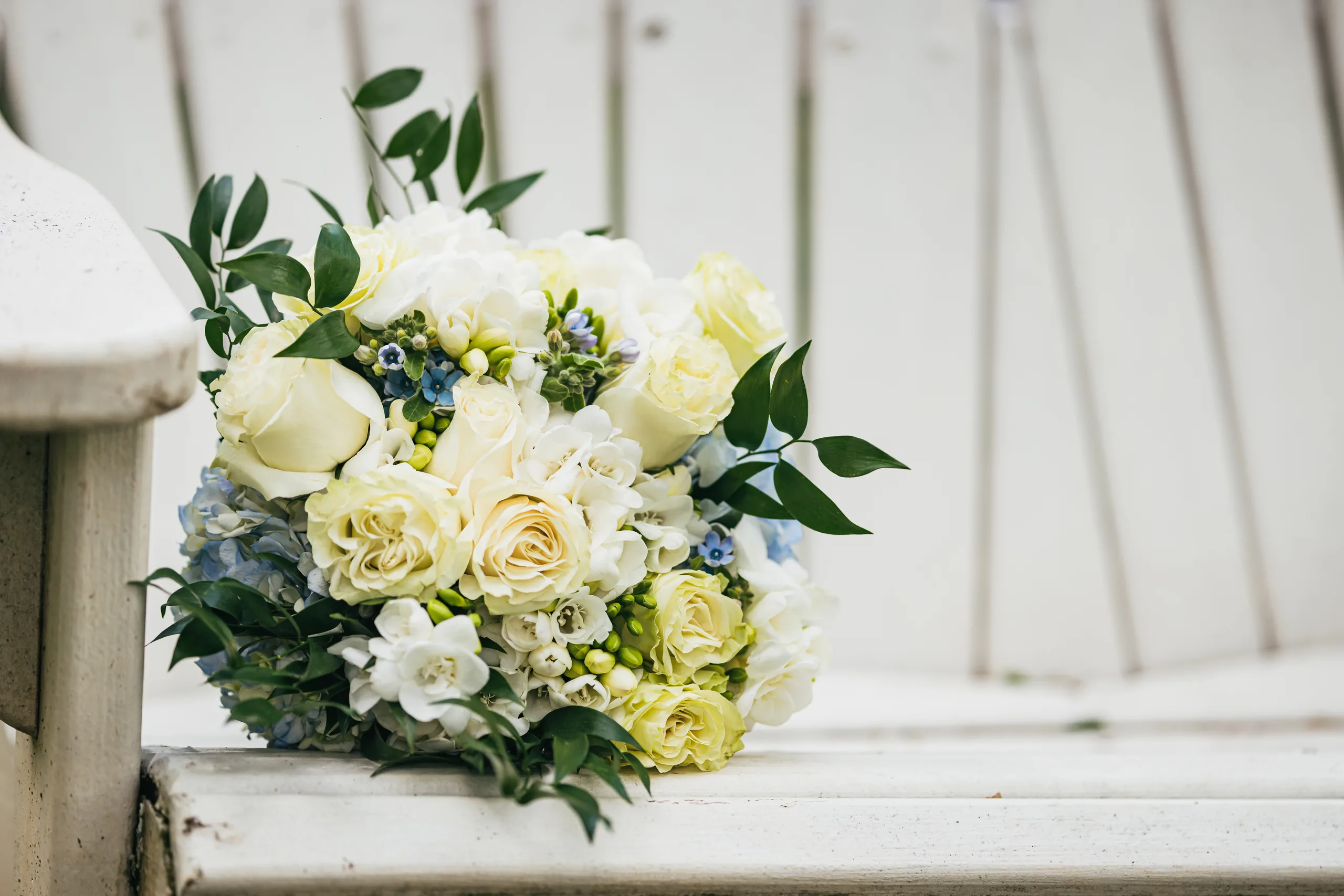 Wedding Florals: her bouquet of white and cream roses on a garden chair at a wedding at the Payne-Corley House in Duluth, GA