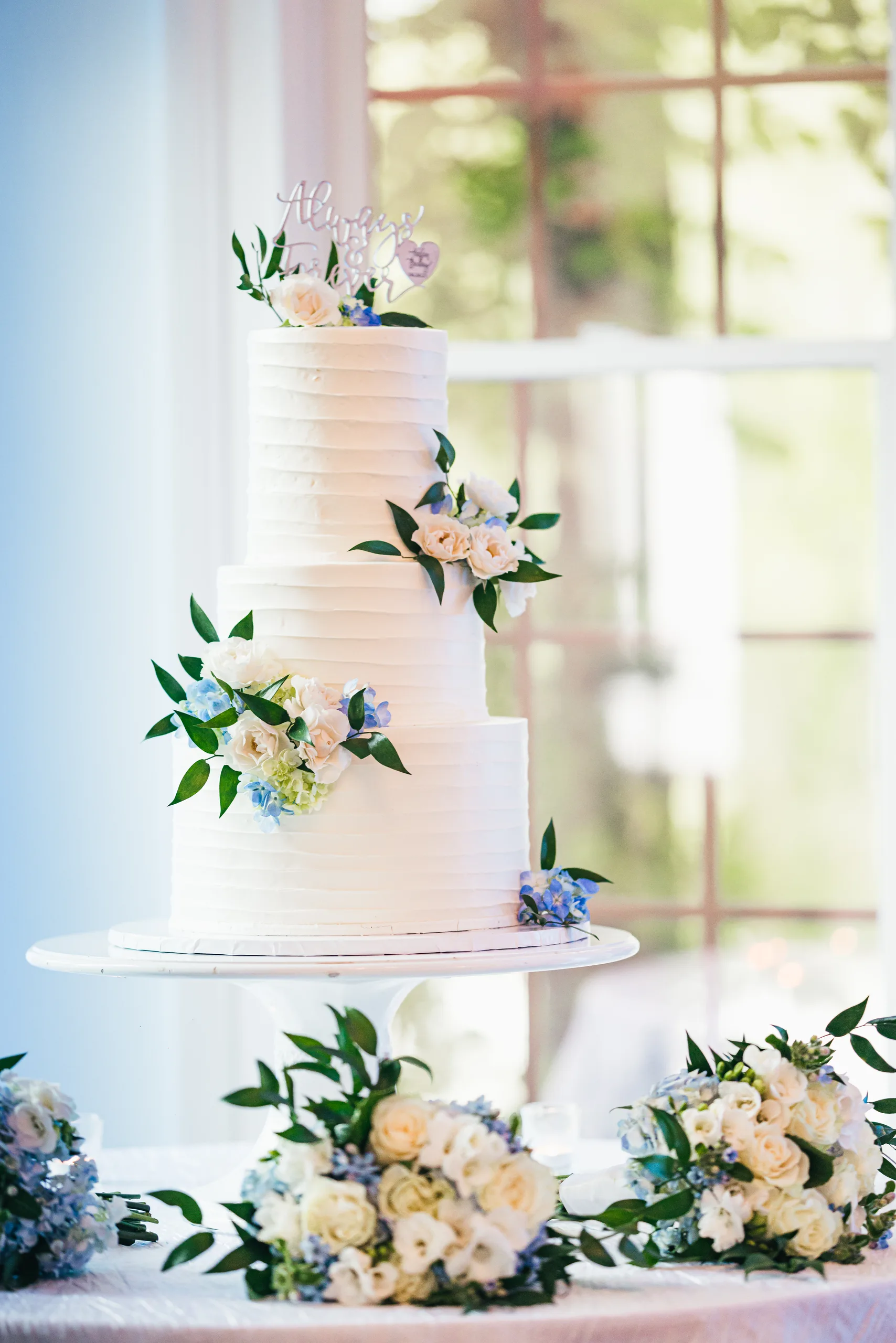 Wedding Cake Details: the four-tier white cake with blush and blue flowers at a wedding at the Payne-Corley House in Duluth, GA