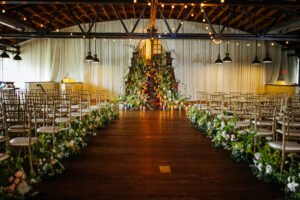 Aisle lined with florals and a full floral installation at a wedding by Martha McIntosh at Summerour Studio in Atlanta, GA