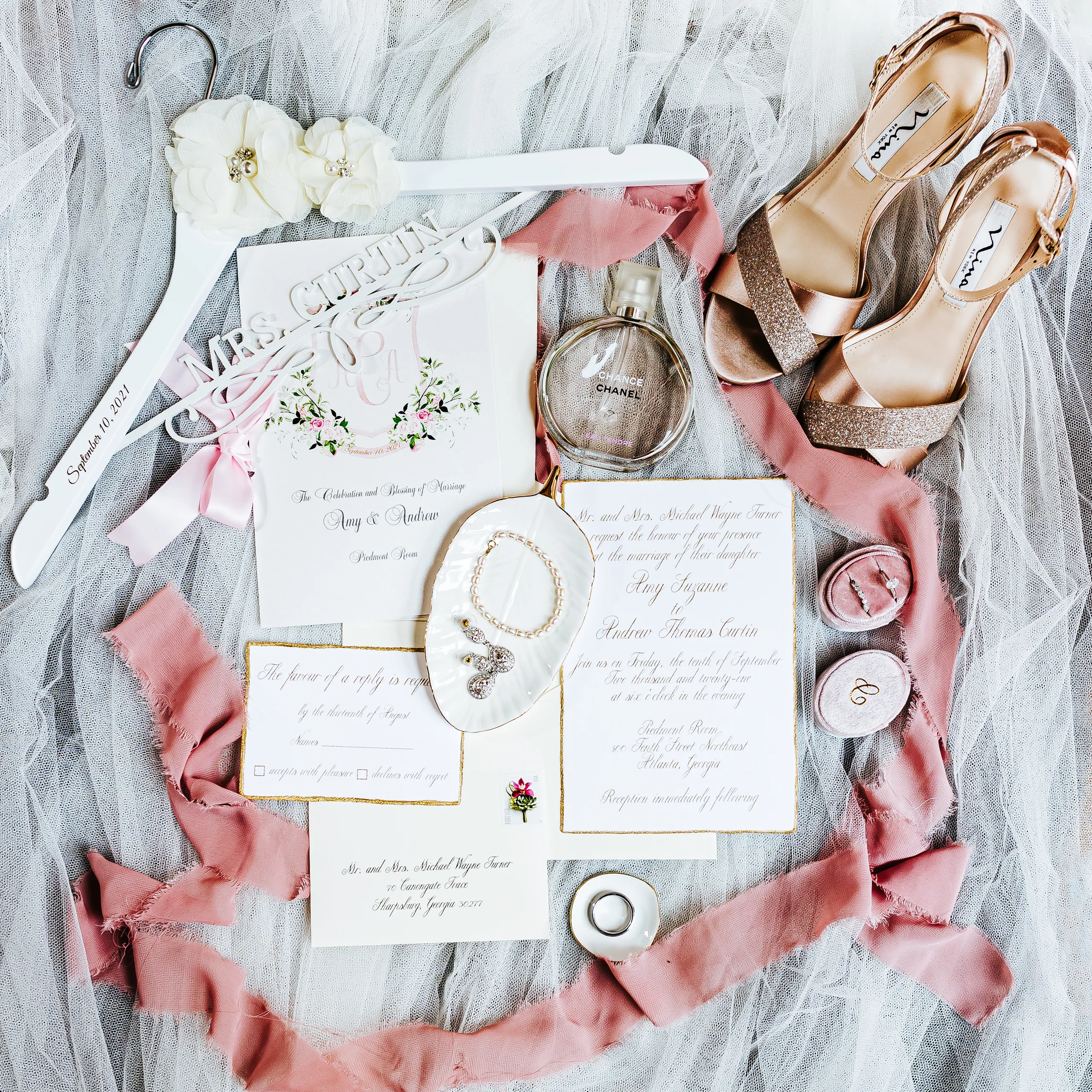 Wedding Details: her invitation suite, heels, perfume and a Mrs. Curtin hanger laid out on tulle, at a wedding at The Piedmont Room in Atlanta, GA