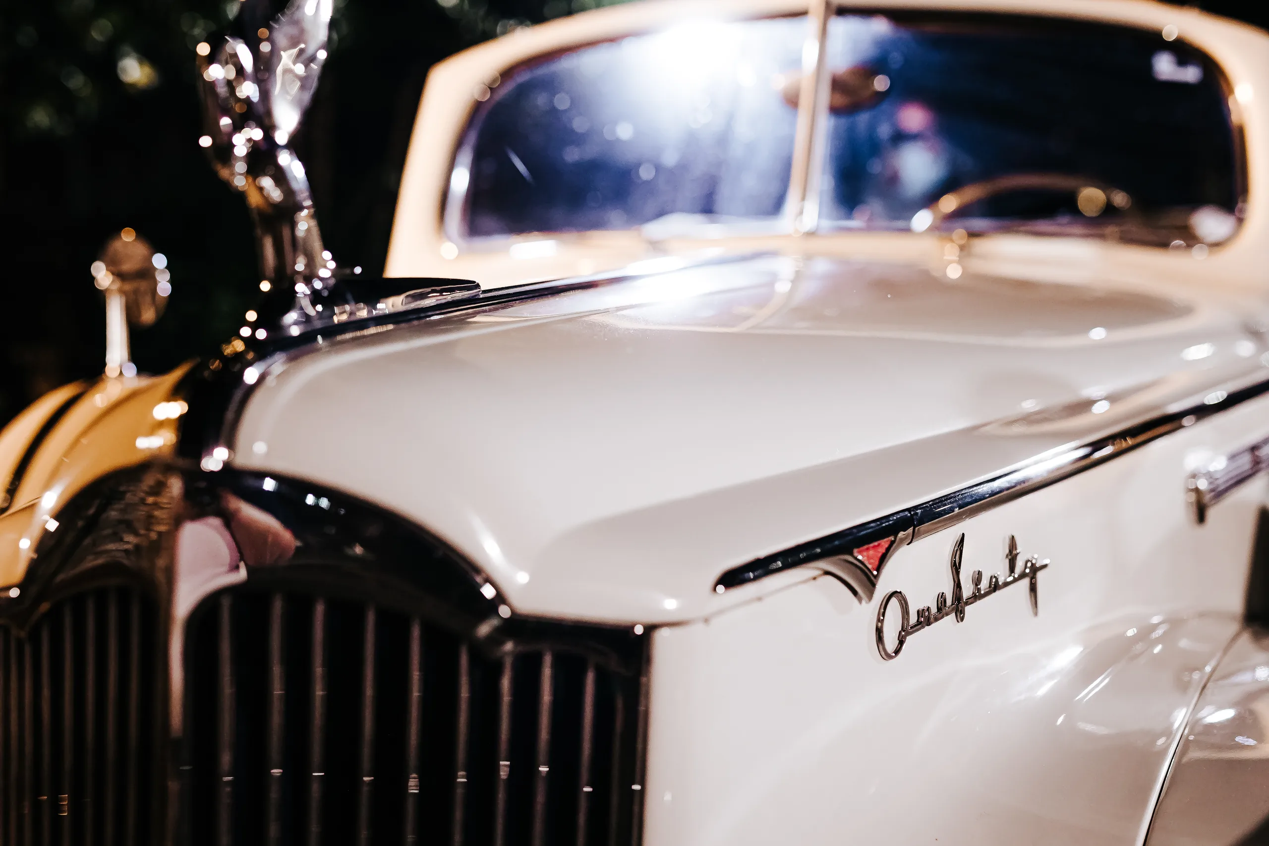 Send-Off: the chrome and white paint of the vintage Packard convertible, at their wedding at The Piedmont Room in Atlanta, GA