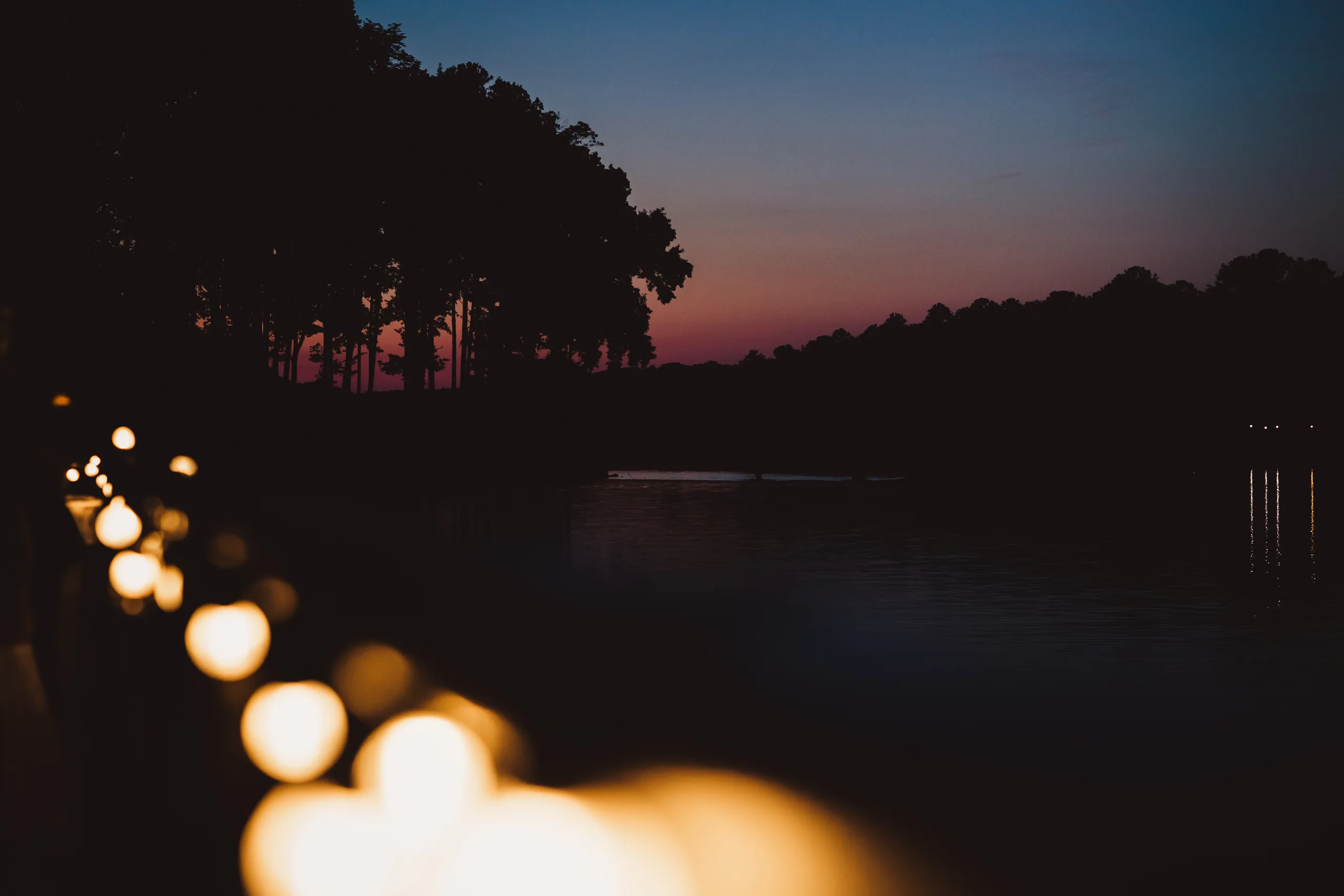 Reception Details: lights along the water at dusk, at a wedding at Atlanta Evergreen Lakeside Resort in Stone Mountain, GA