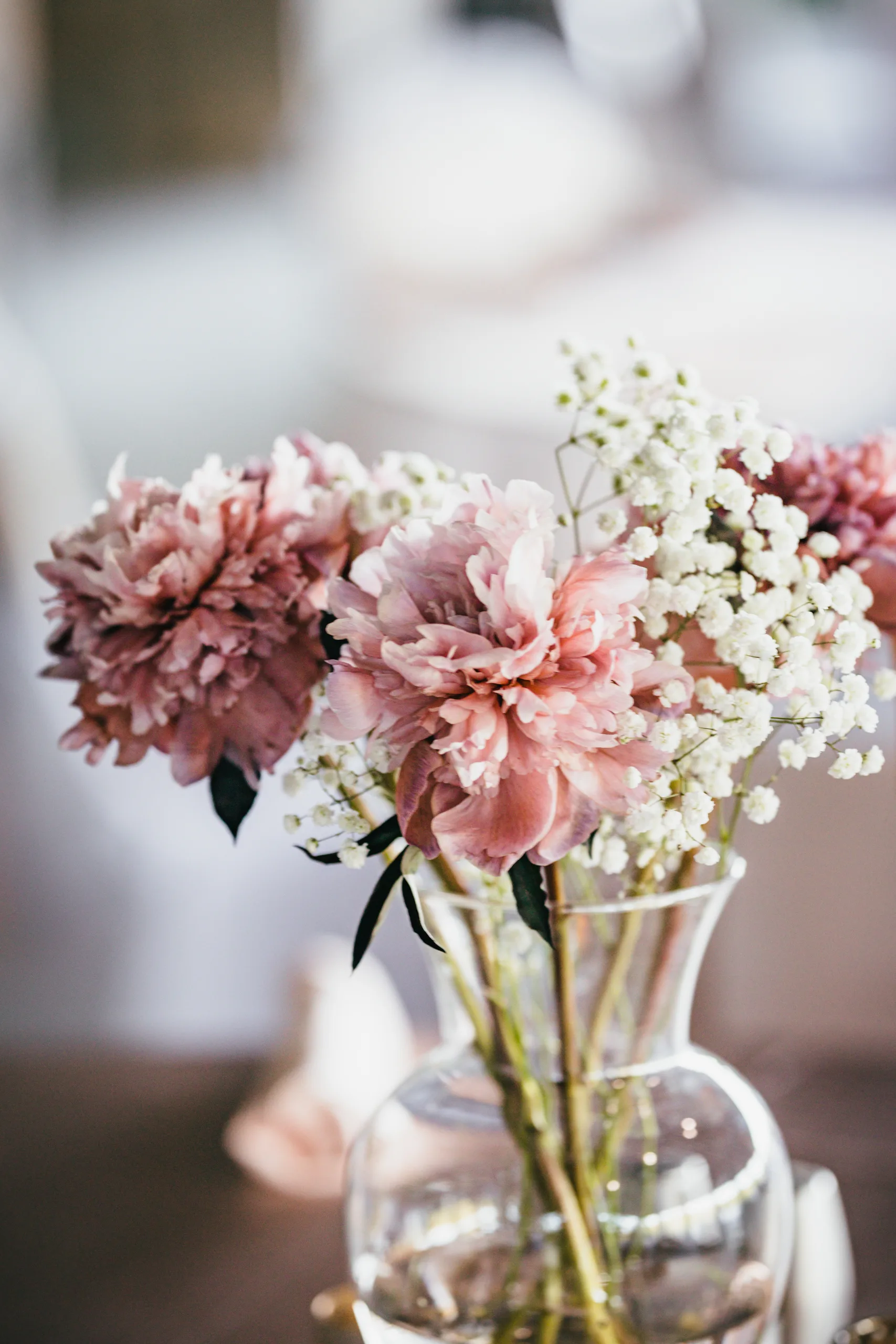 Reception Details: blush flowers and baby's breath in a glass vase, at a wedding at Atlanta Evergreen Lakeside Resort in Stone Mountain, GA