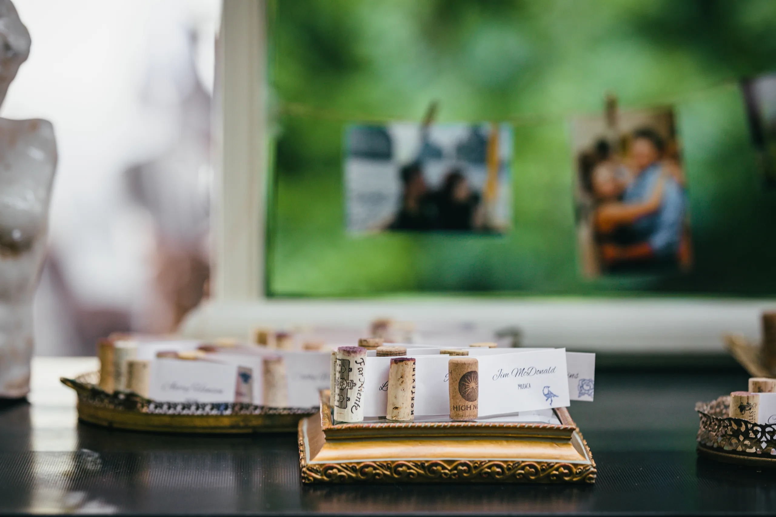 Reception Details: escort cards in wine corks with their photos hung behind, at a wedding at Atlanta Evergreen Lakeside Resort in Stone Mountain, GA