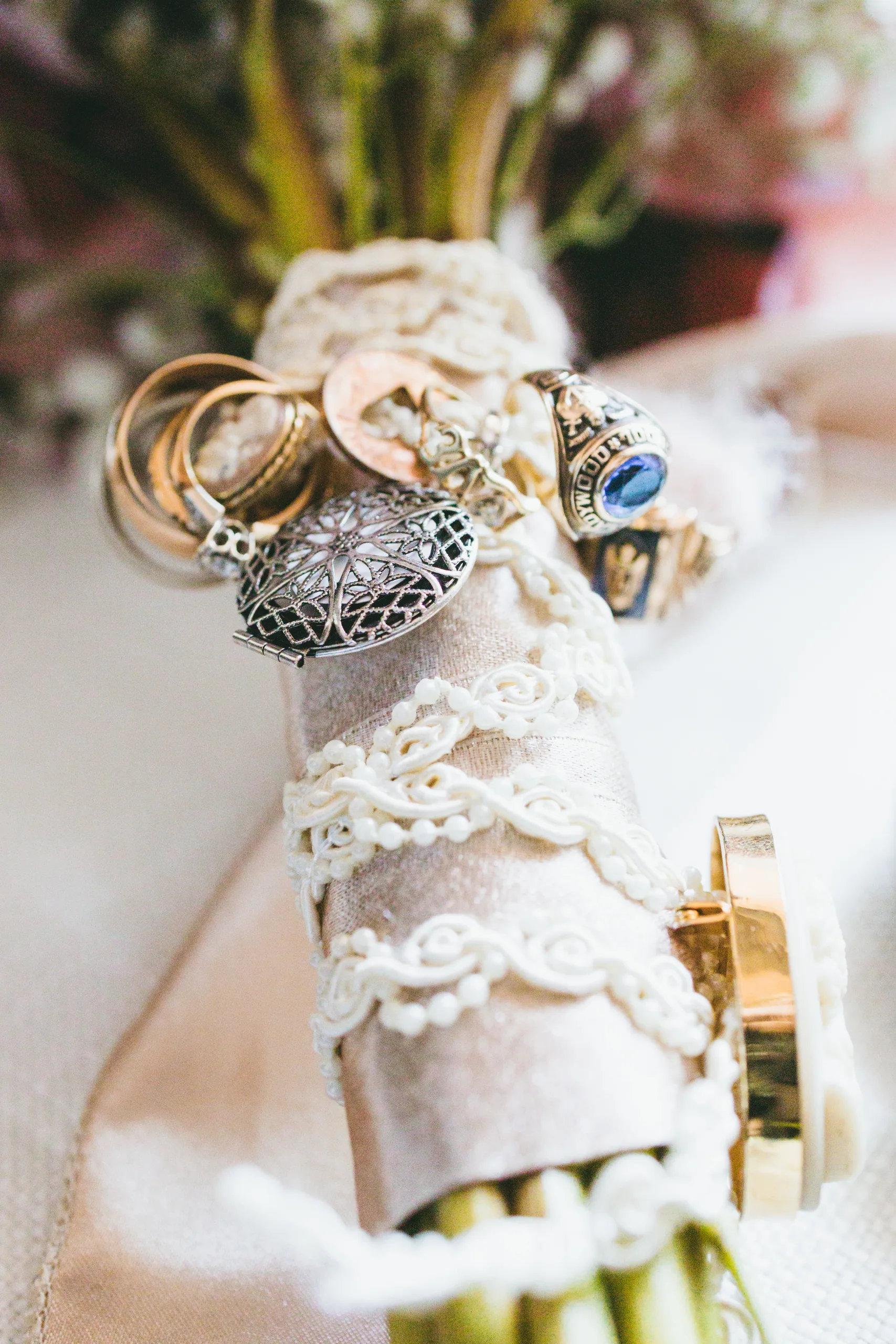 Wedding Florals: family rings and lockets wrapped around the stems of her bouquet, at a wedding at Atlanta Evergreen Lakeside Resort in Stone Mountain, GA