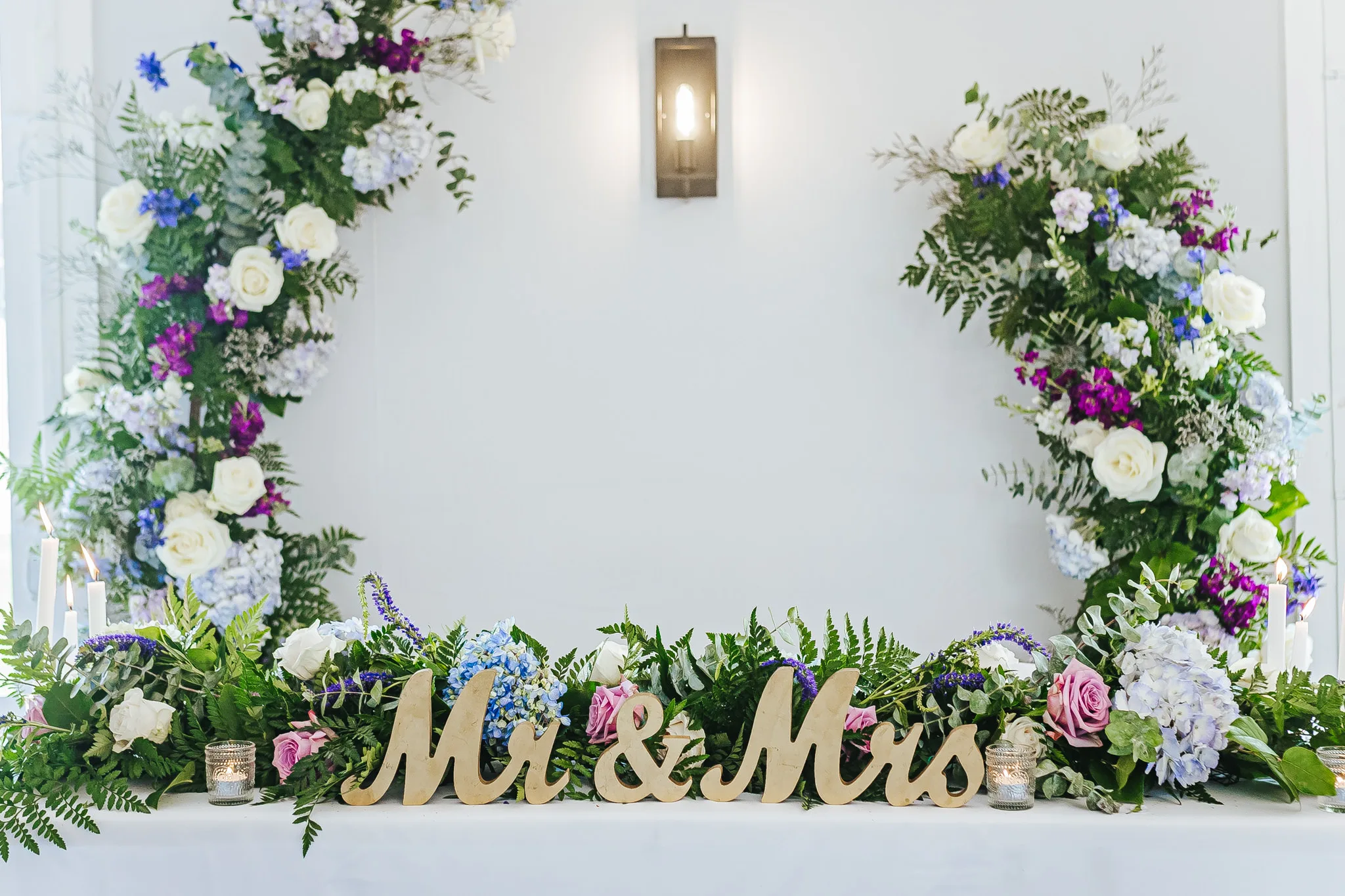 Reception Details: the sweetheart table with florals and a gold Mr and Mrs sign, at a wedding at The Wildflower 301 in Greensboro, GA
