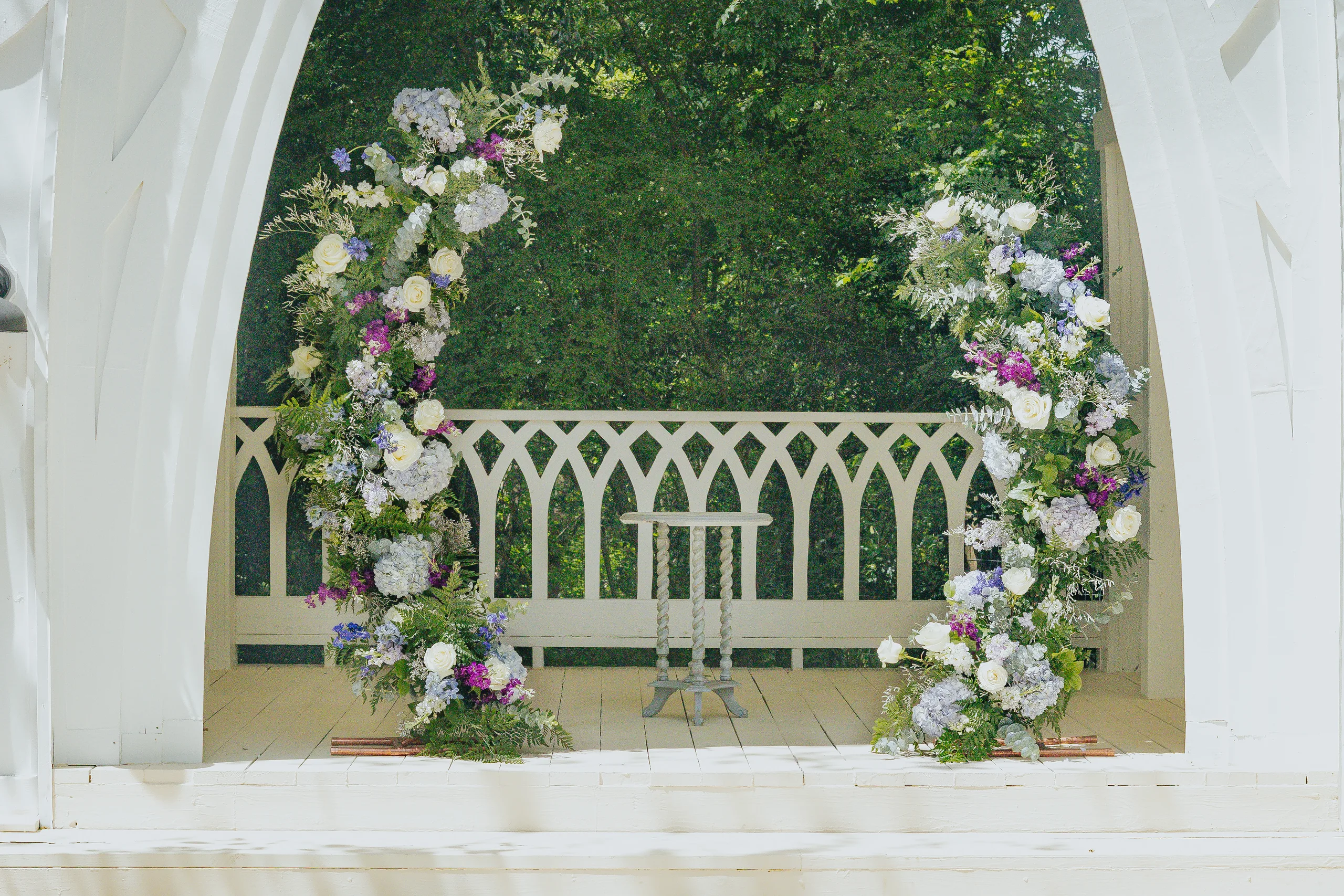 Wedding Florals: purple and white flowers on both sides of the chapel arch, at a wedding at The Wildflower 301 in Greensboro, GA