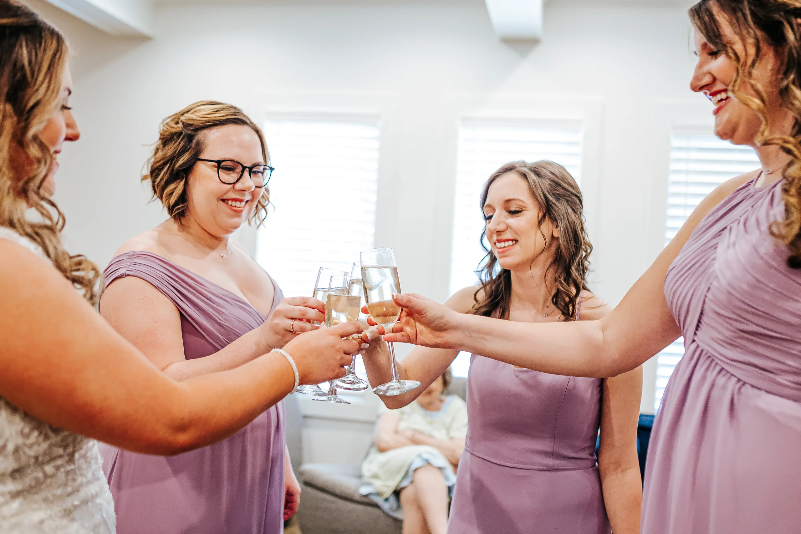Getting Ready: a champagne toast with her bridesmaids in lavender before their wedding at the Country Club of Roswell in Roswell, GA
