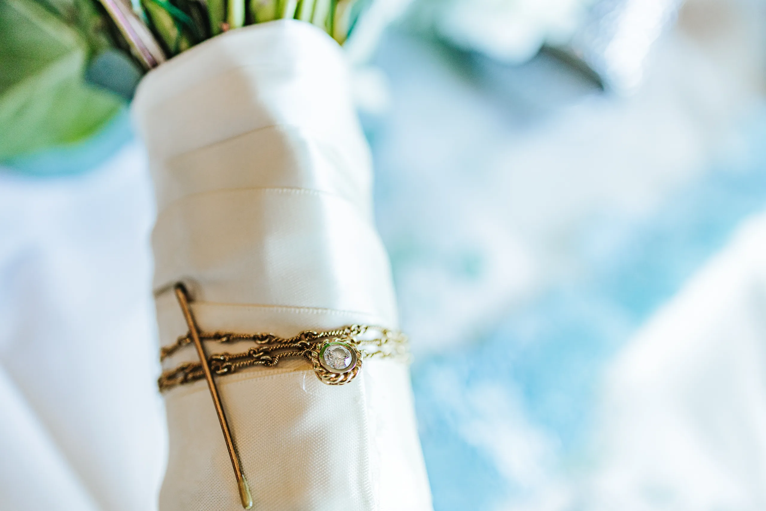 Wedding Details: a small locket pinned to her bouquet wrap at a wedding at the Country Club of Roswell in Roswell, GA