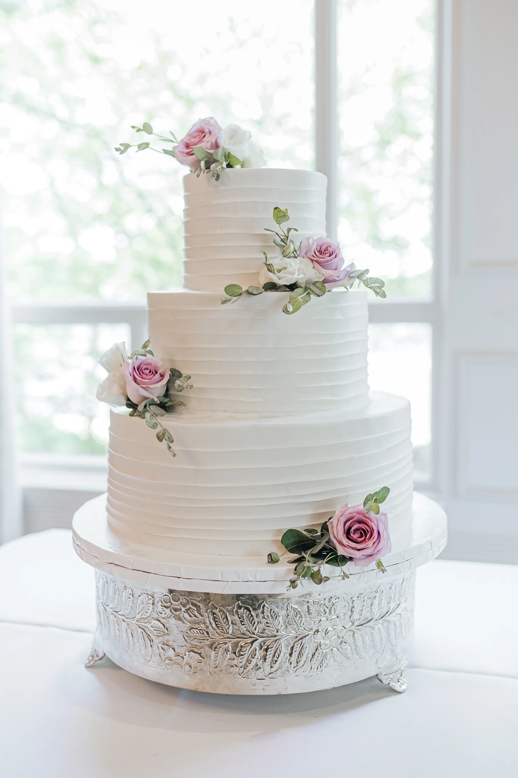 Wedding Cake Details: the three-tier white cake with lavender roses at a wedding at the Country Club of Roswell in Roswell, GA