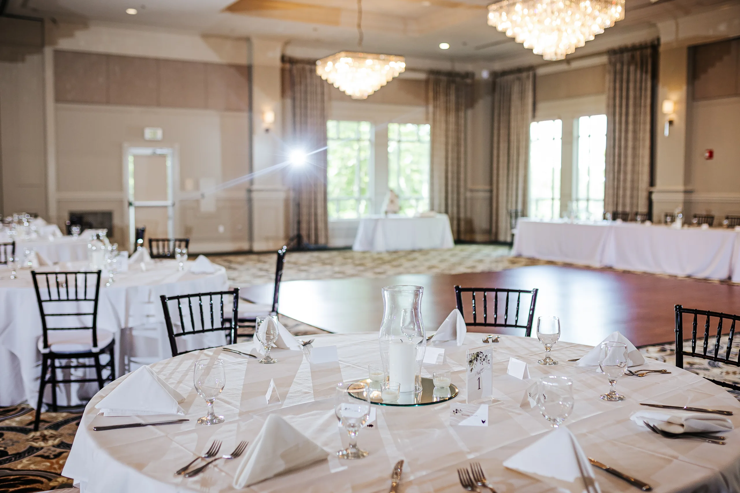 Reception Details: the ballroom set with chandeliers and white linens at a wedding at the Country Club of Roswell in Roswell, GA