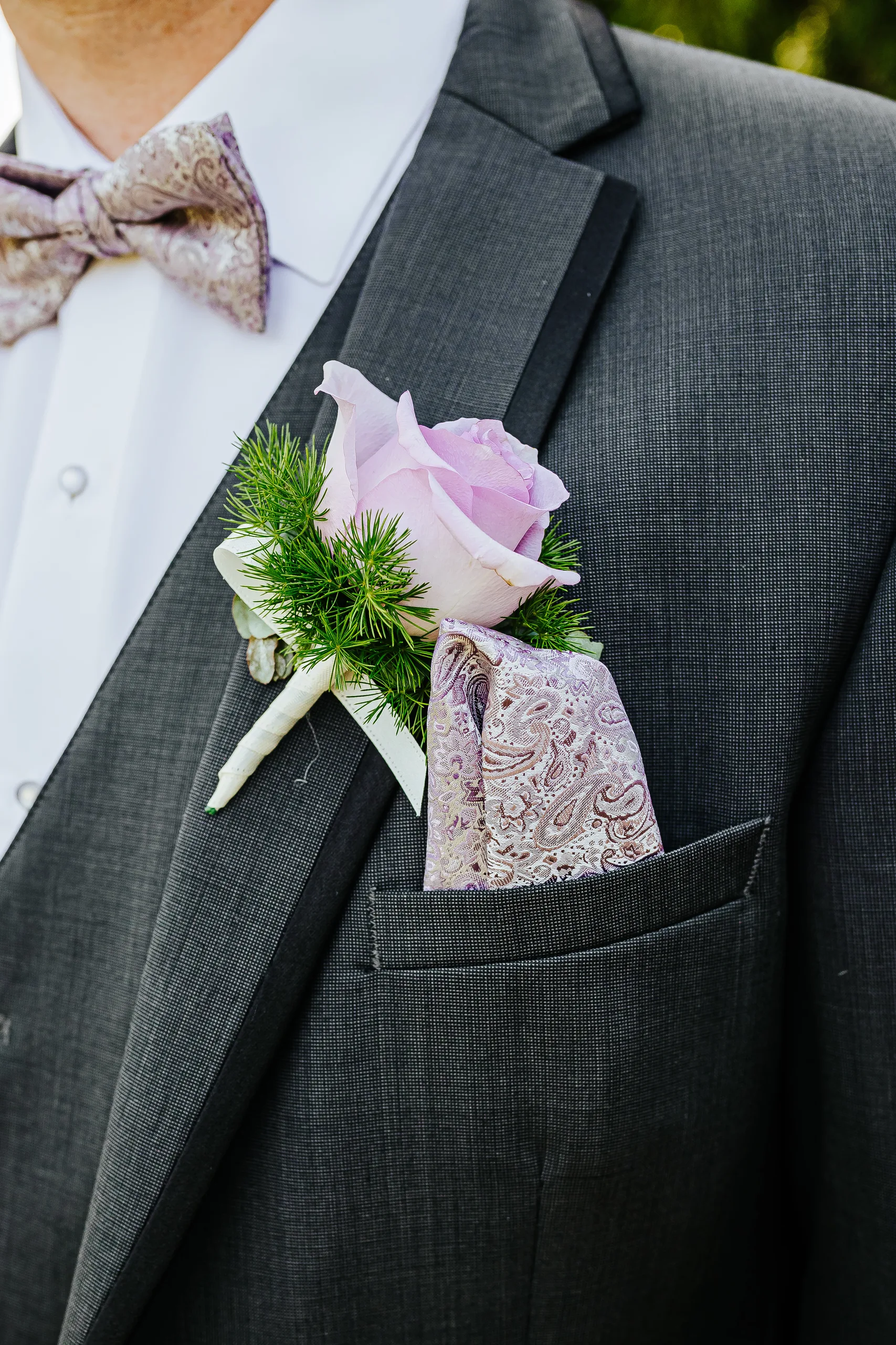 Wedding Details: his lavender rose boutonniere and paisley bow tie at a wedding at the Country Club of Roswell in Roswell, GA