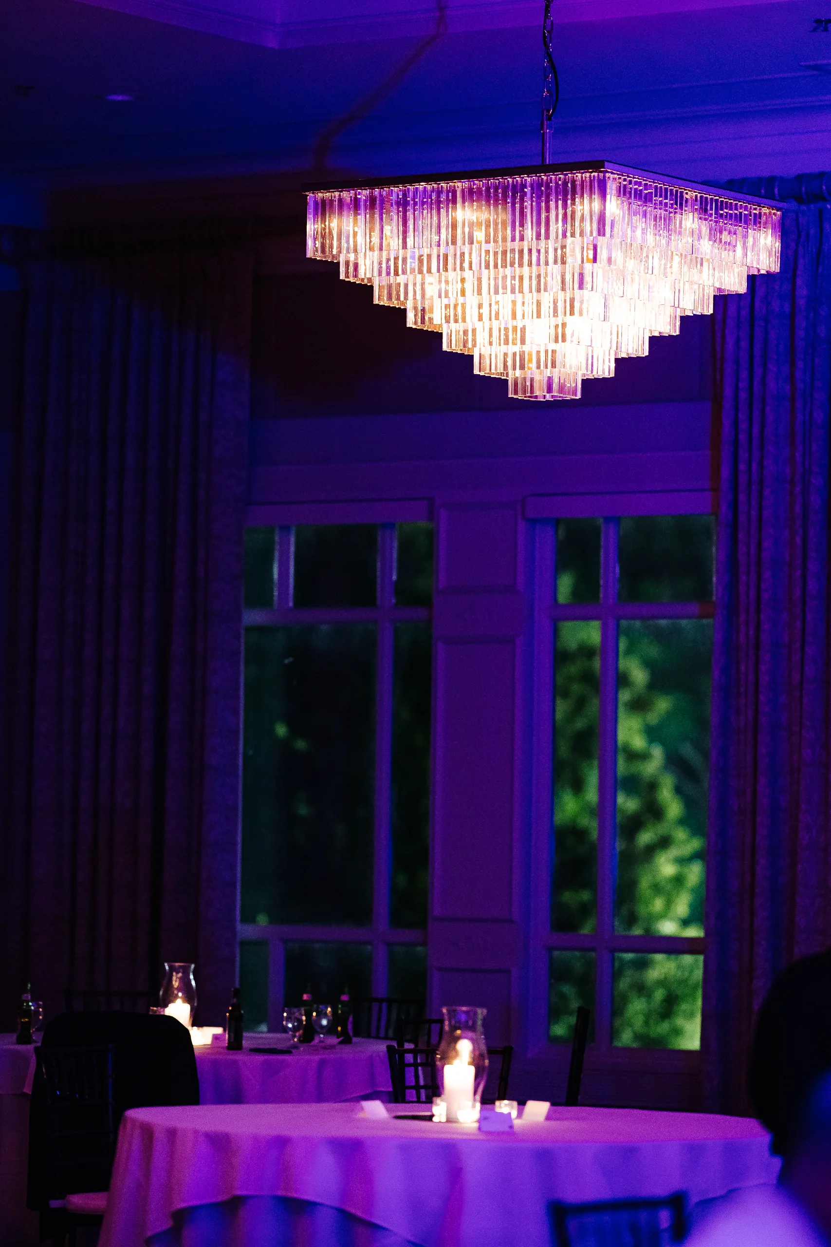 Reception Details: the chandelier in purple light at a wedding at the Country Club of Roswell in Roswell, GA