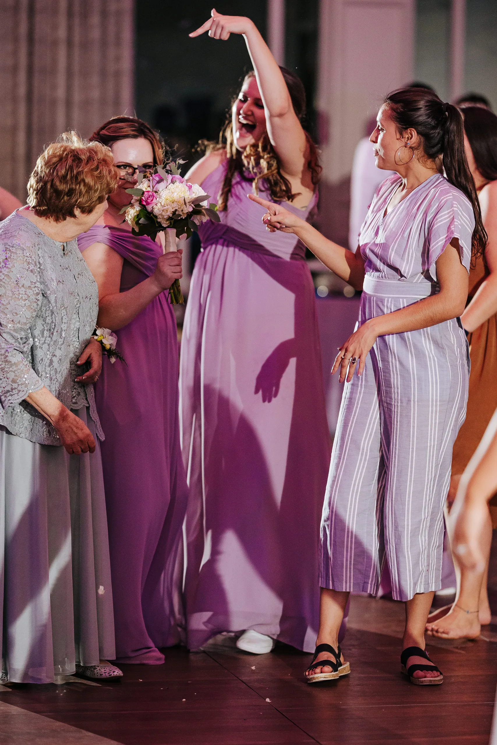 Reception: a bridesmaid celebrating after catching the bouquet at their wedding at the Country Club of Roswell in Roswell, GA